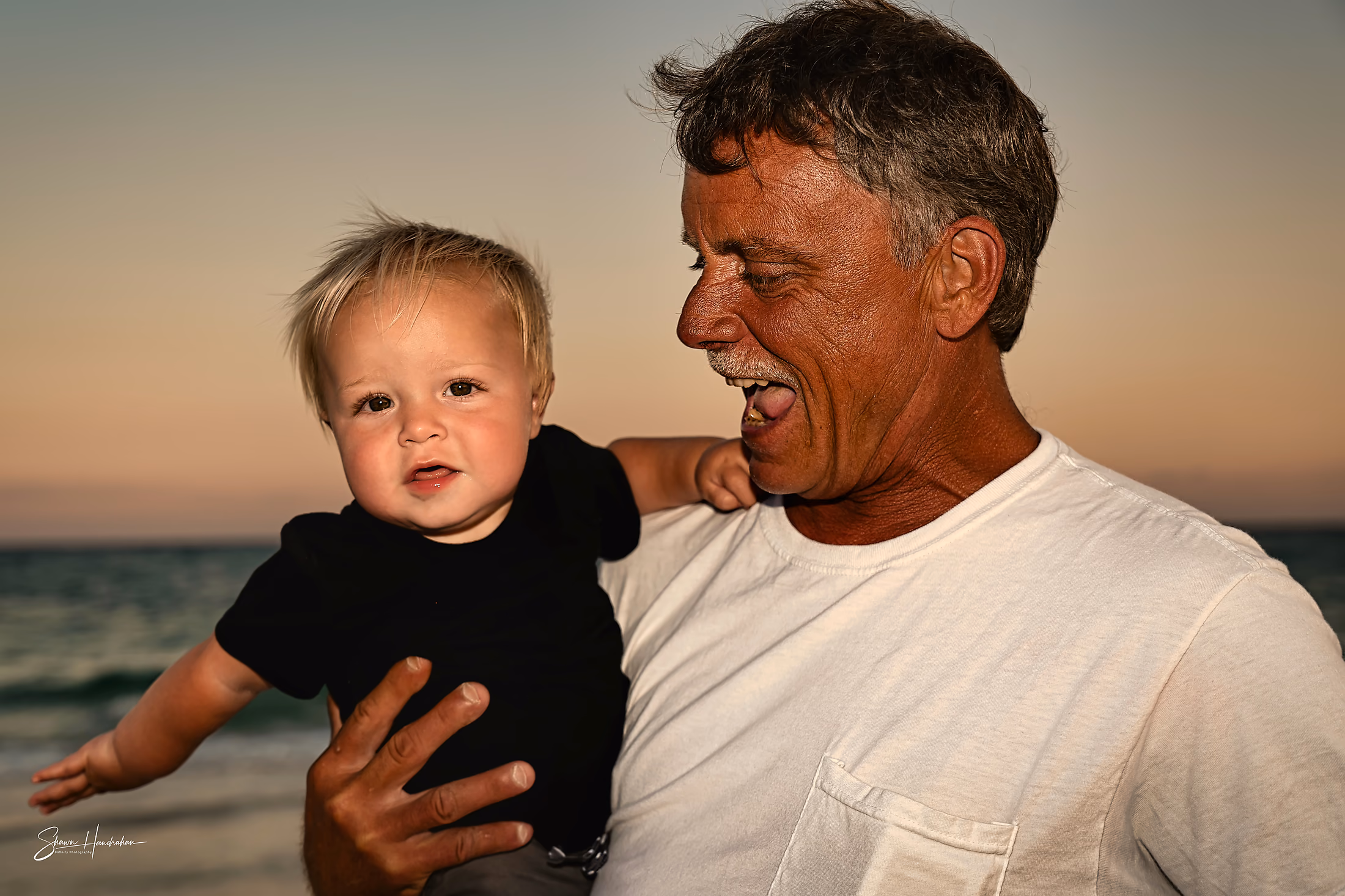 Grandfather and his grandson sharing a moment on the beach
