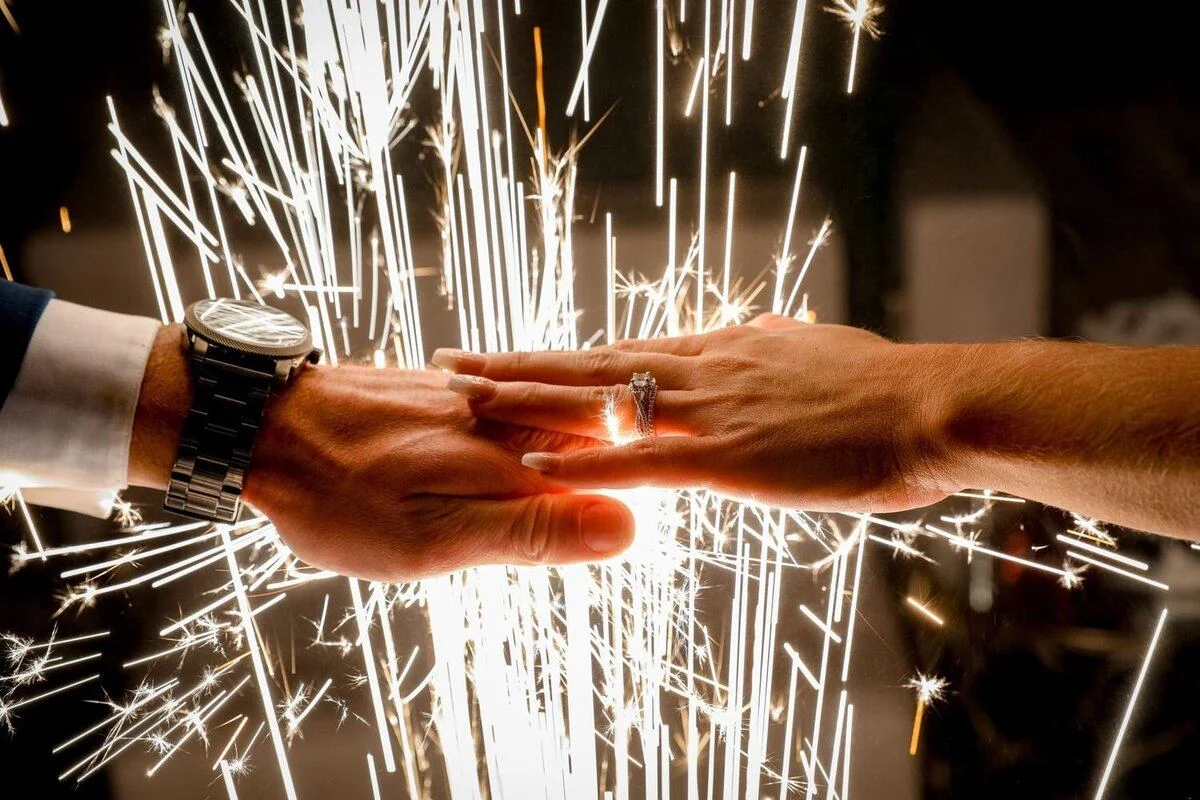 Sparkler glowing between hands at night