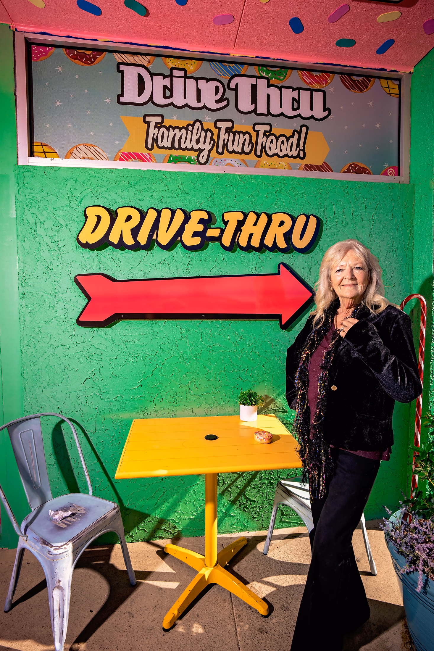 Woman posing in front of a vintage drive-thru mural