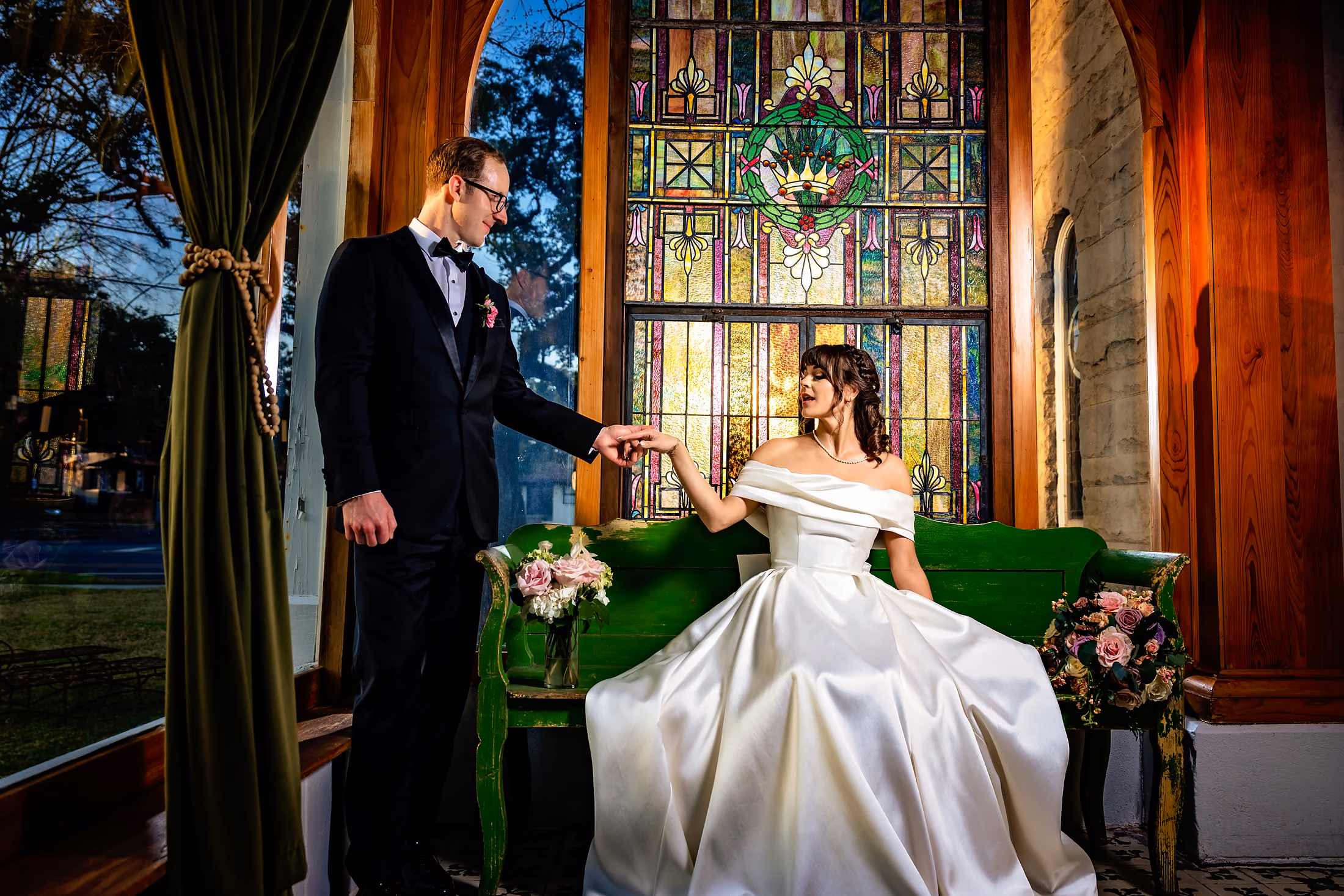 Bride by the stained-glass window in a sleek gown