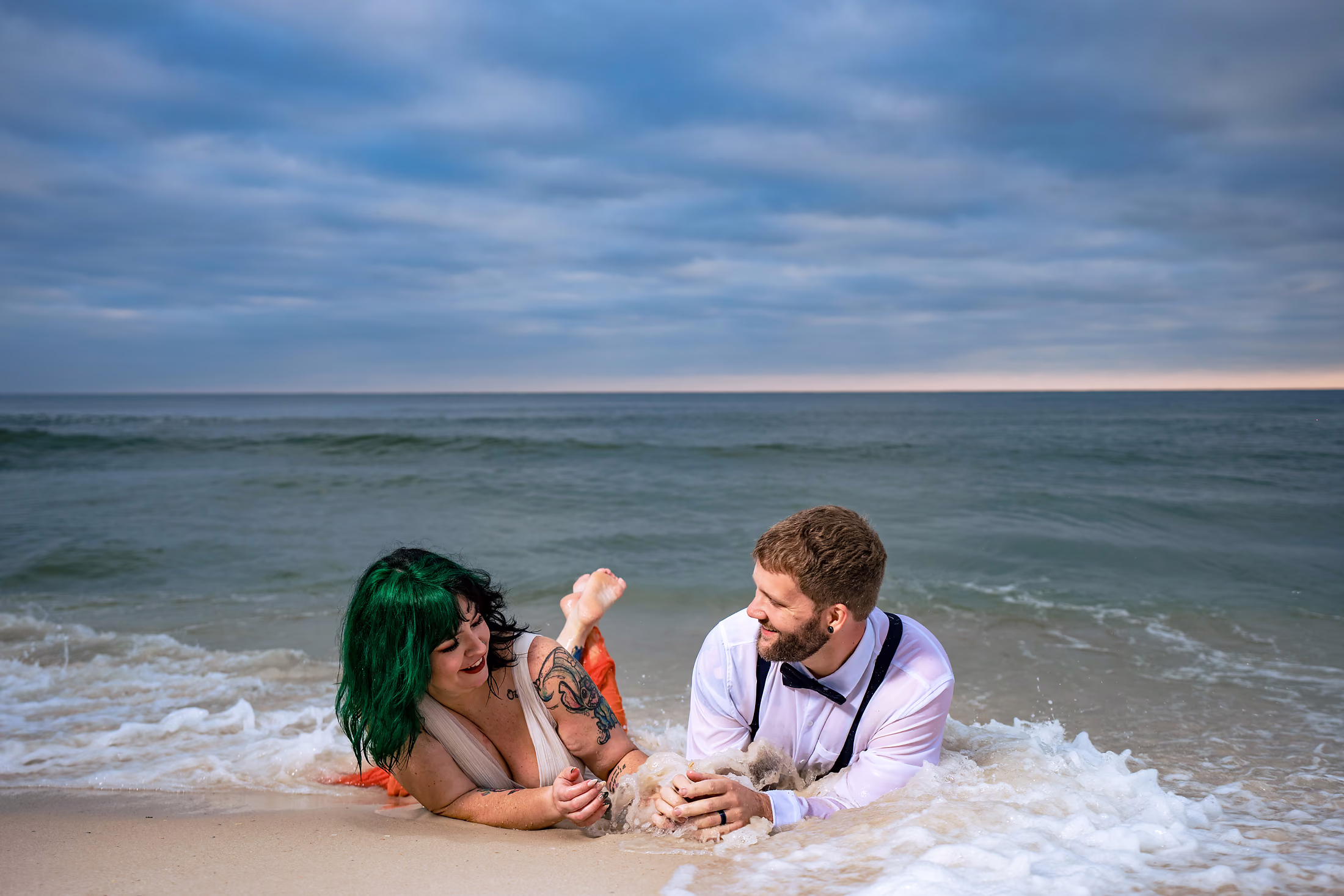 Couple laughing together in the shallow surf