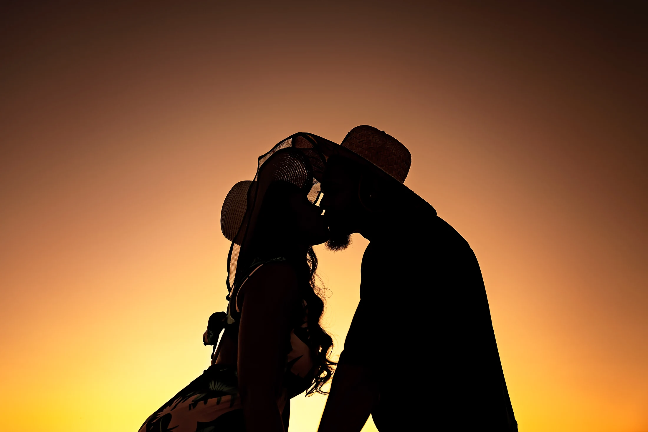 Lone figure silhouetted against a vivid orange sunset