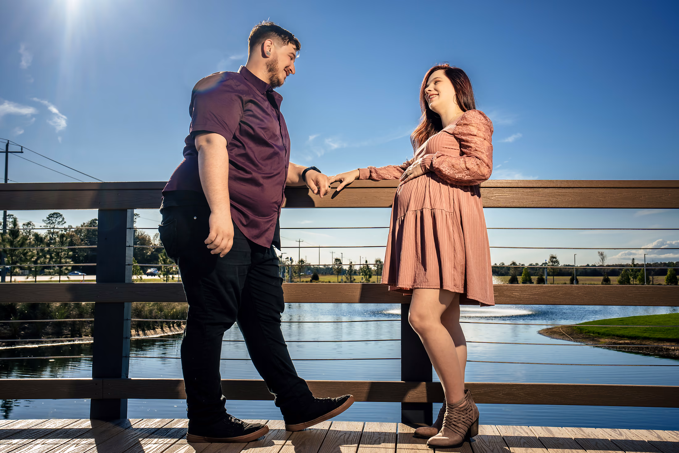 Couple holding hands along a waterfront boardwalk