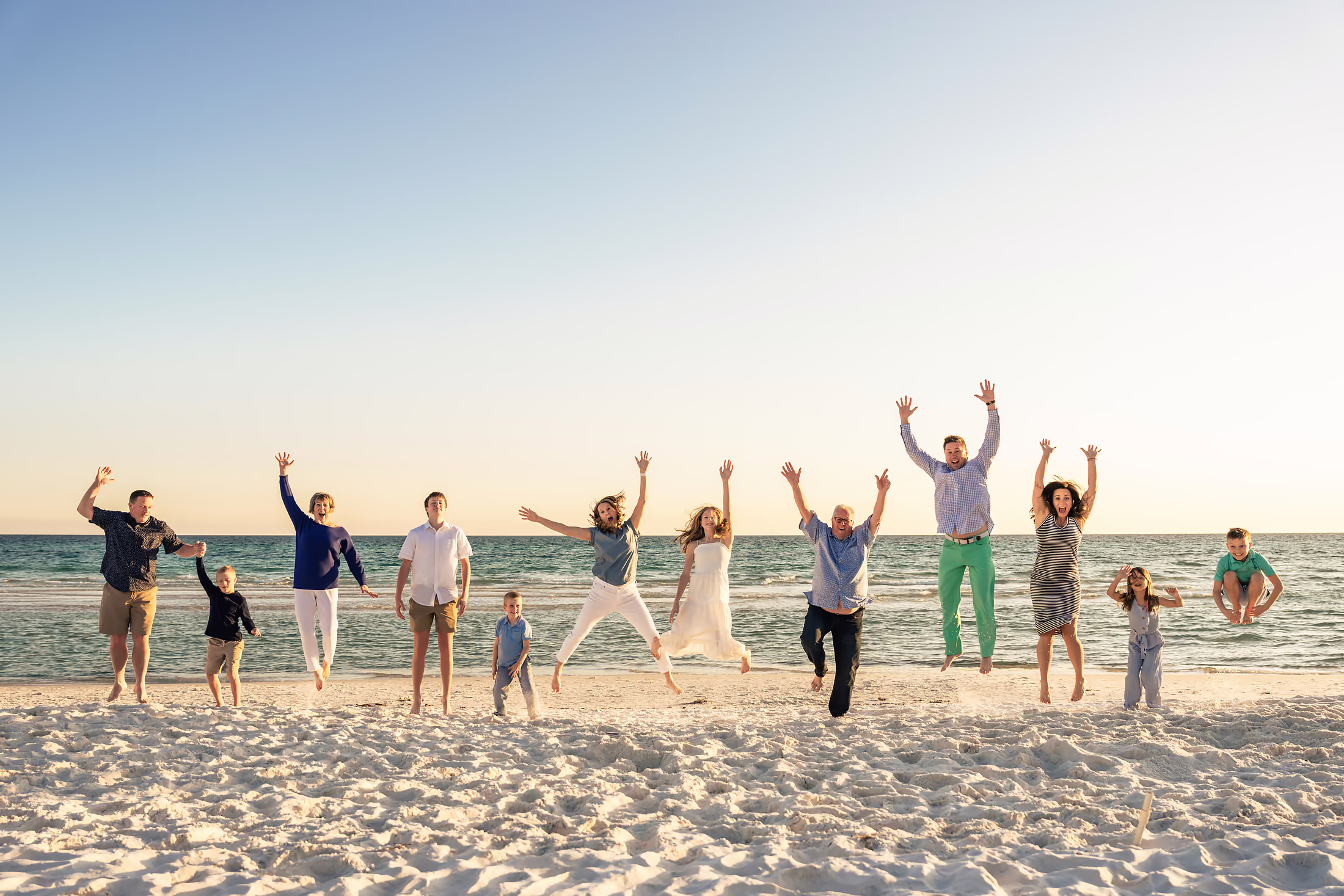 Family throwing their hands up together on the beach