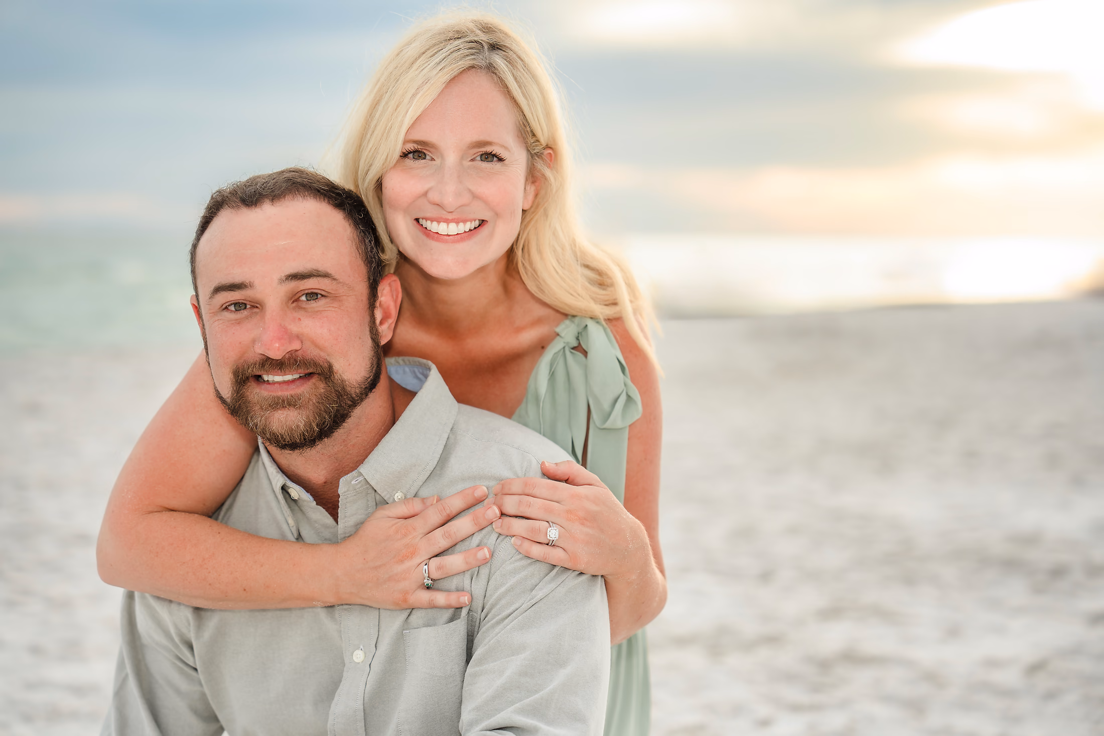 Couple laughing as he carries her along the beach