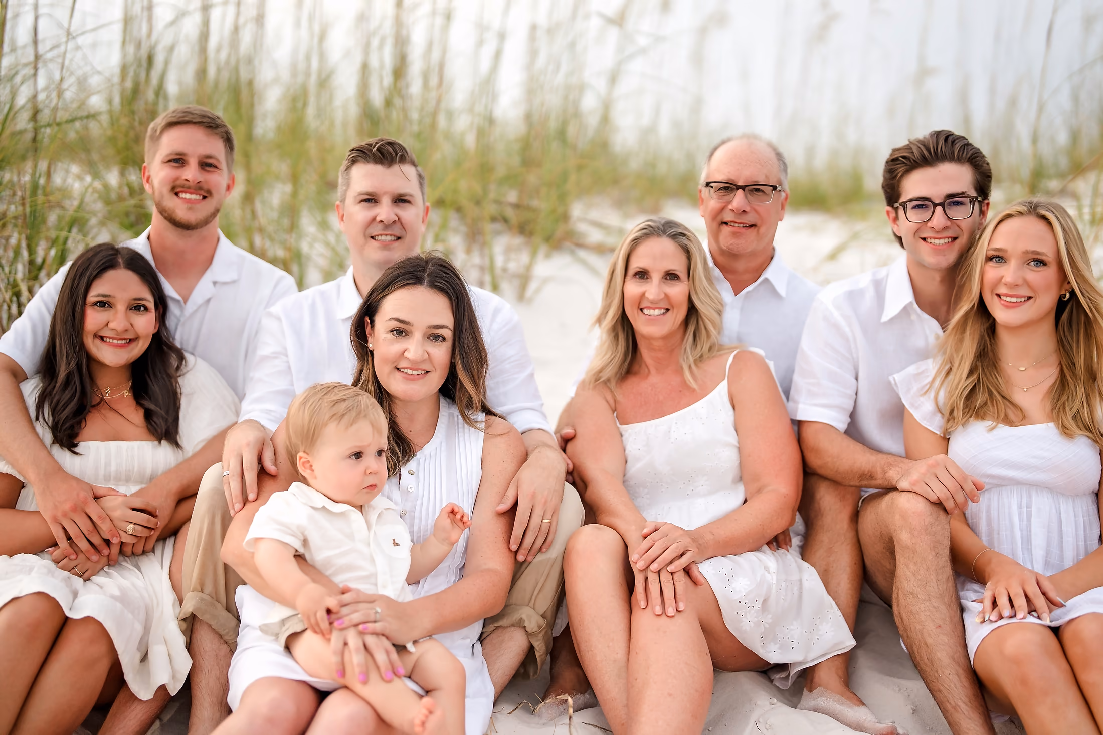 Family in white gathered together in the dunes