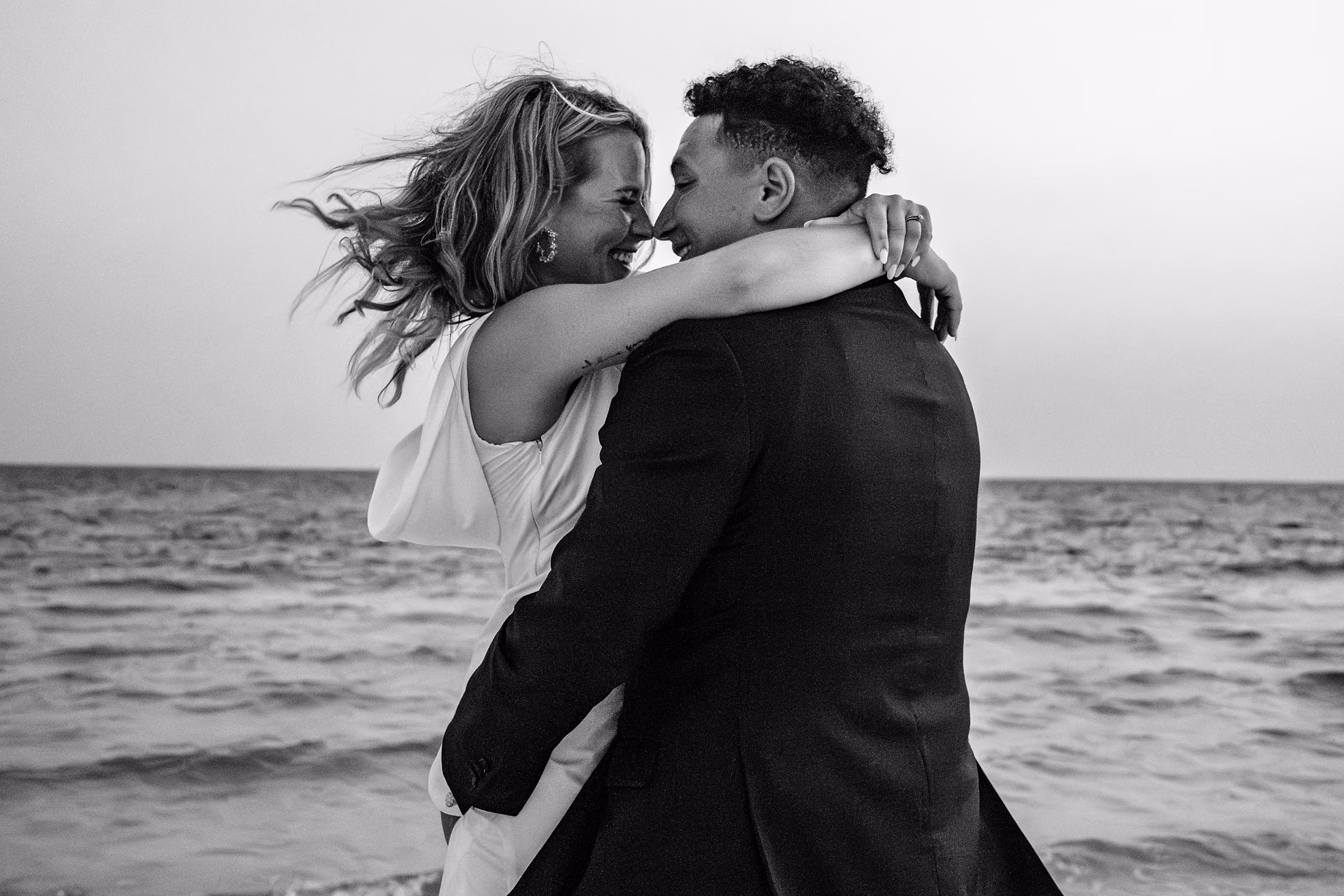 Black-and-white windswept kiss on the beach
