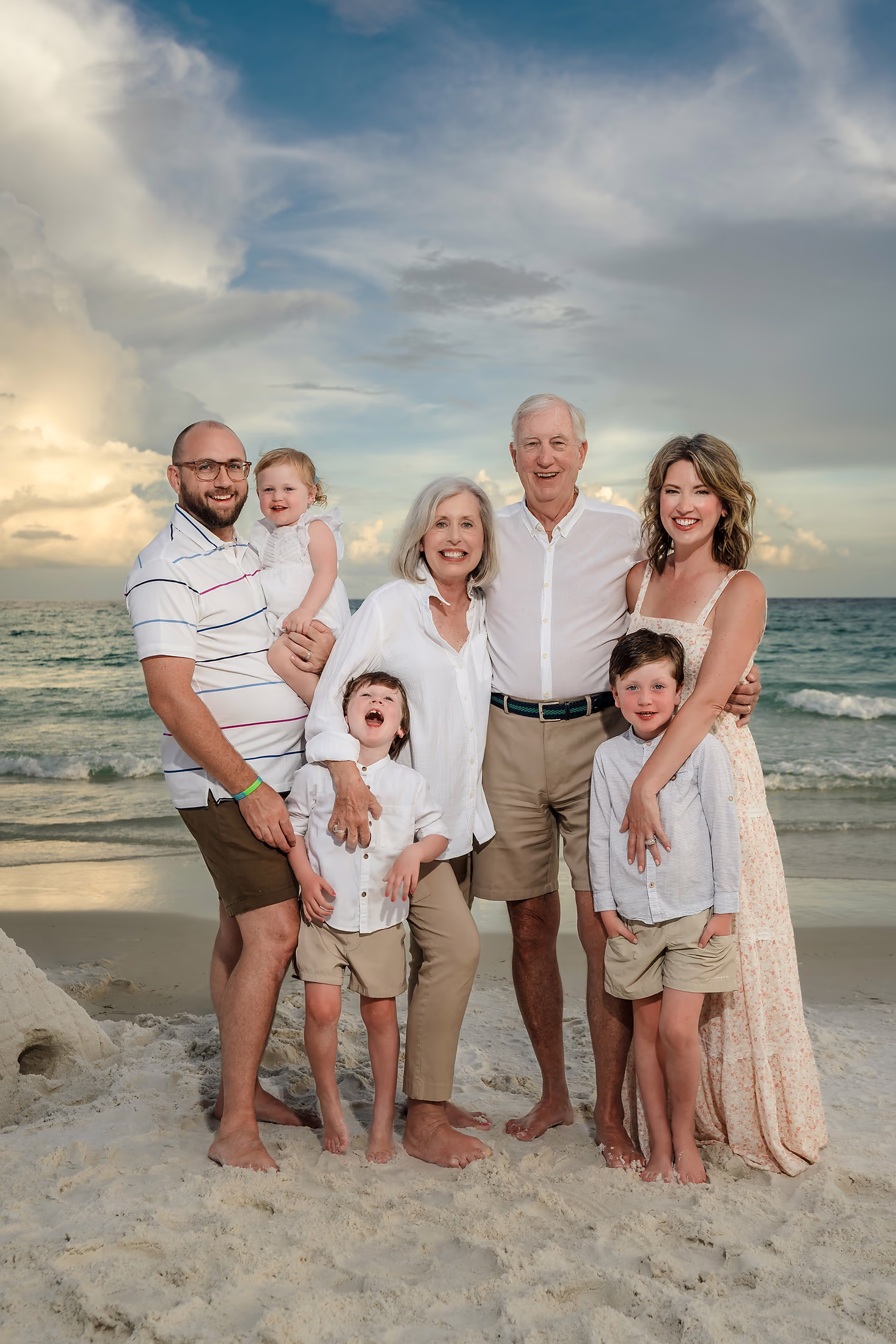 Three generations together on the beach at dusk
