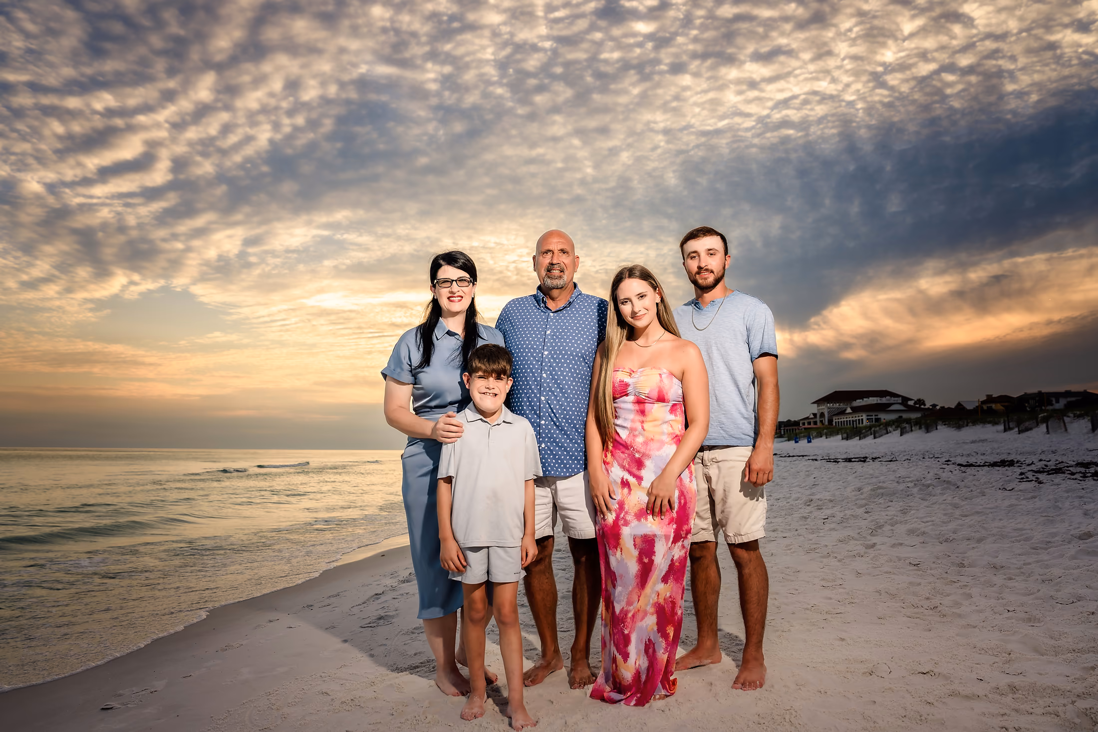 Extended family in coordinated colors on the beach at dusk