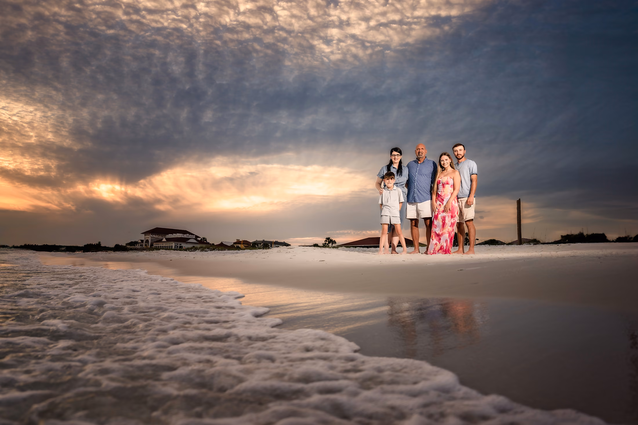 Family small against a vast sky and breaking surf