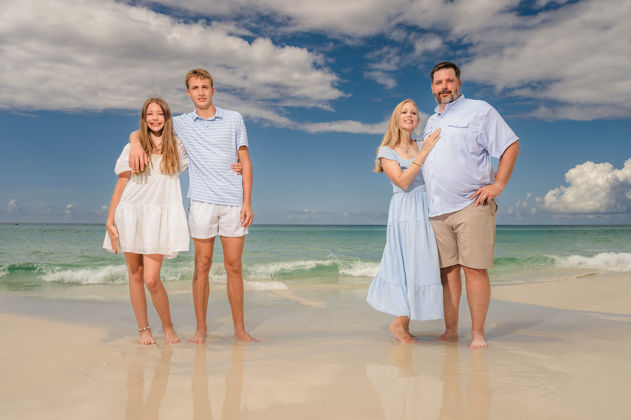 Brother and sister on the beach above turquoise water