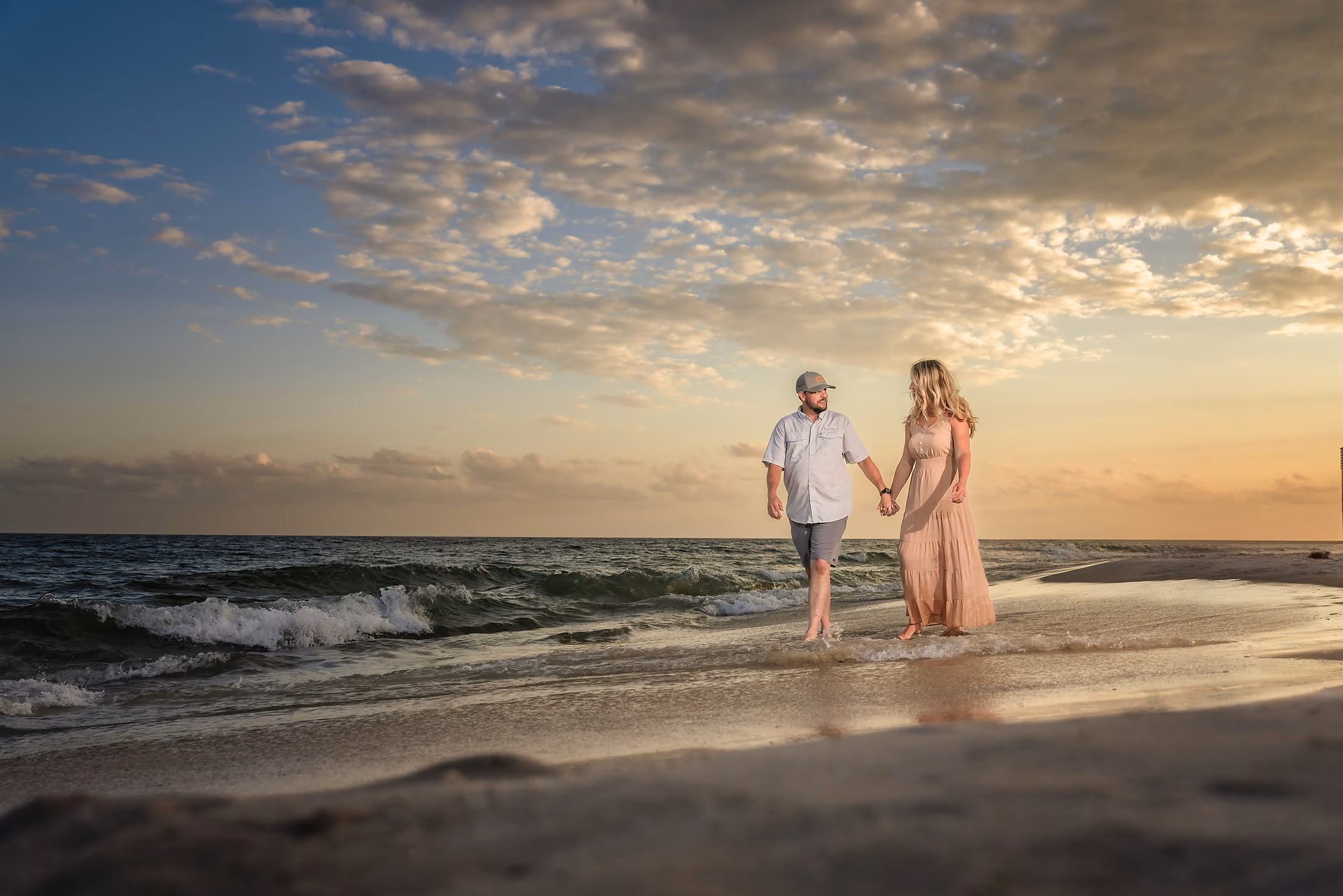Couple holding hands on the beach at sunset