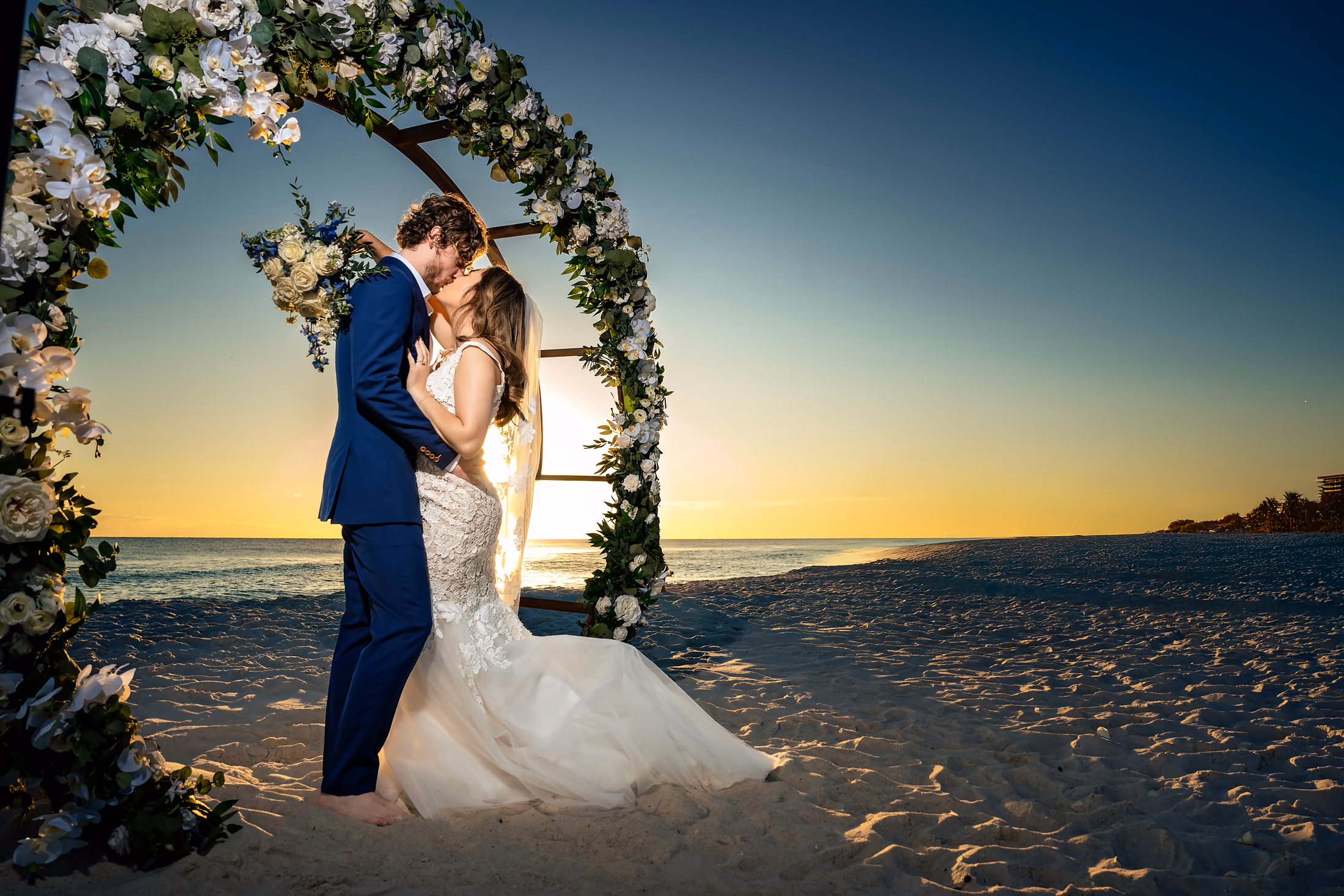 Couple under a beach arch at sunset
