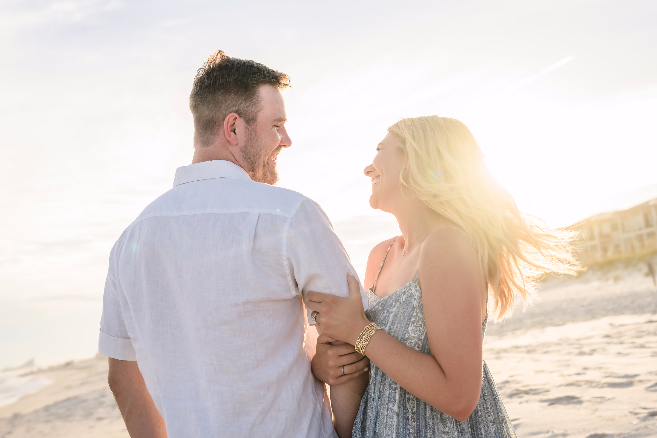 Couple laughing face to face in the backlight