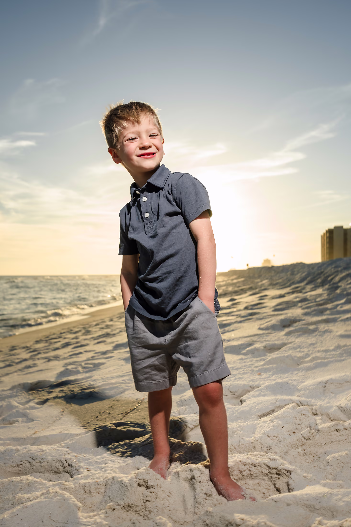 Young boy on the beach as the sun goes down