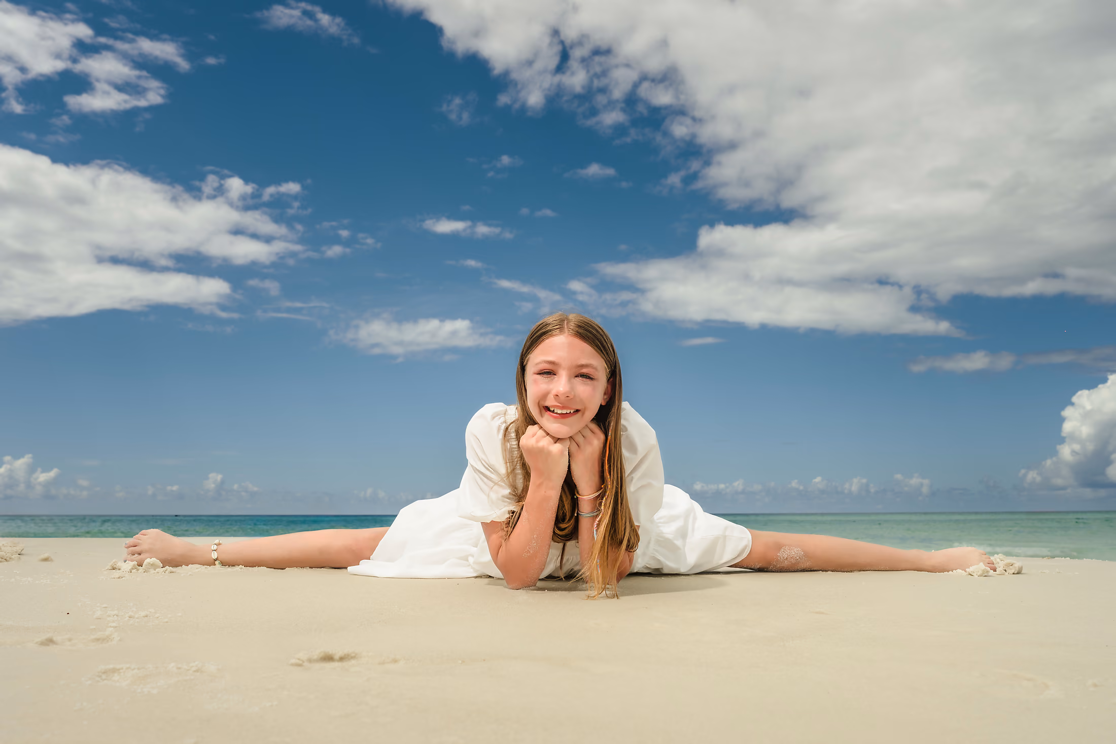 Young girl stretching playfully on the sand