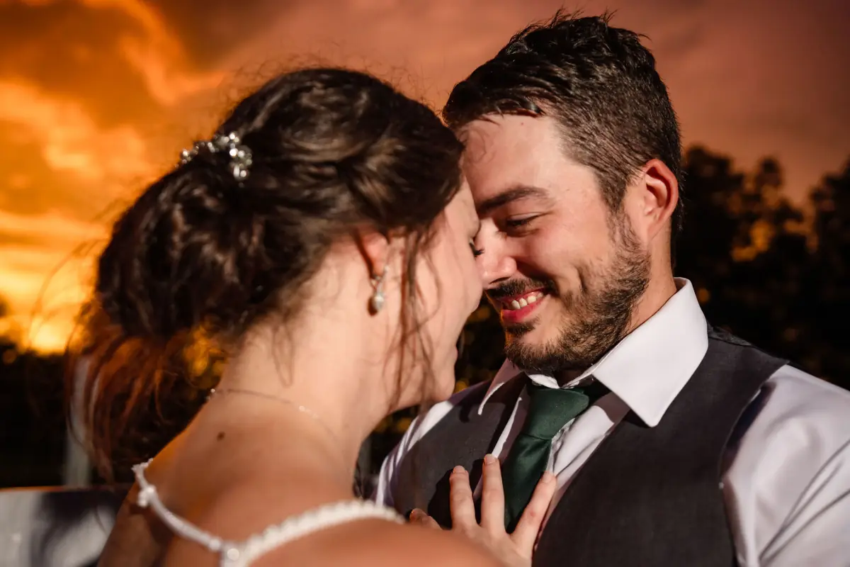 Foreheads together against a fiery sunset at Sowell Farms