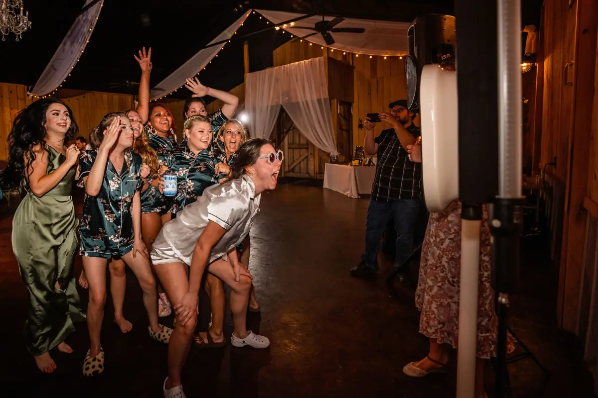 Wedding party laughing together in the Sowell Farms barn