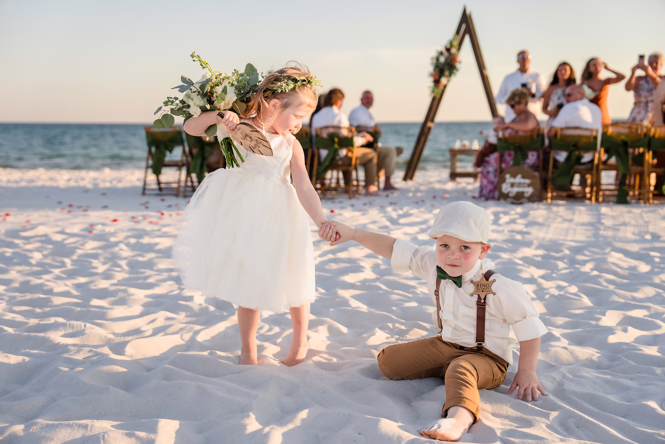 Beach ceremony beneath a triangular arch
