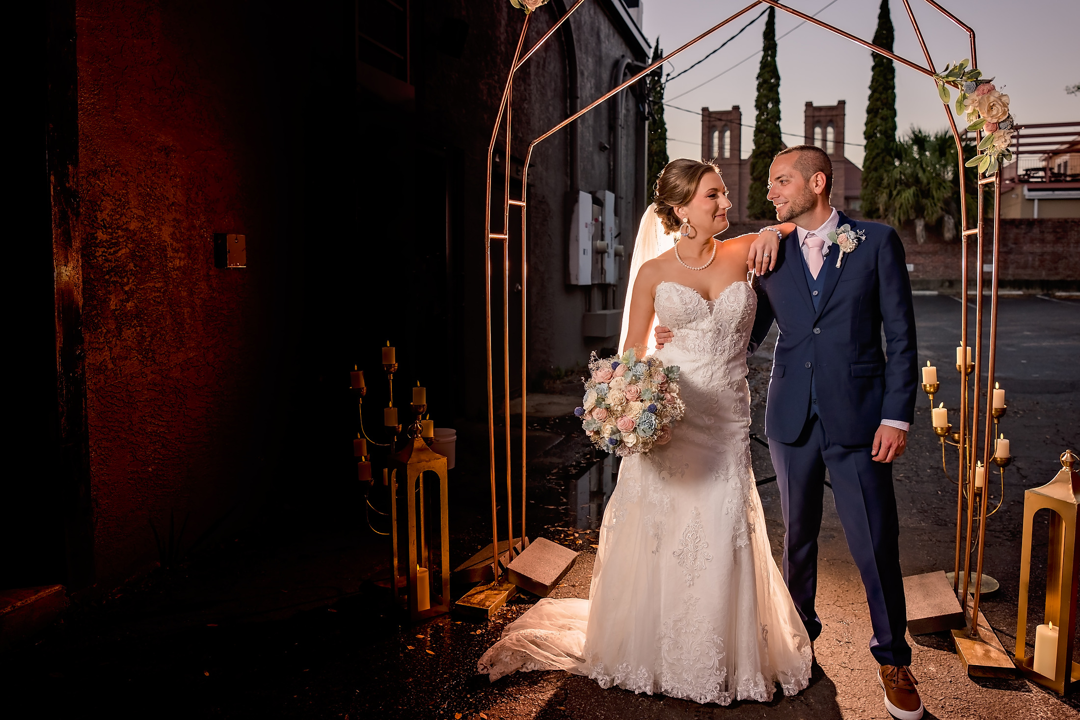 Couple by the brick wall in rosy light