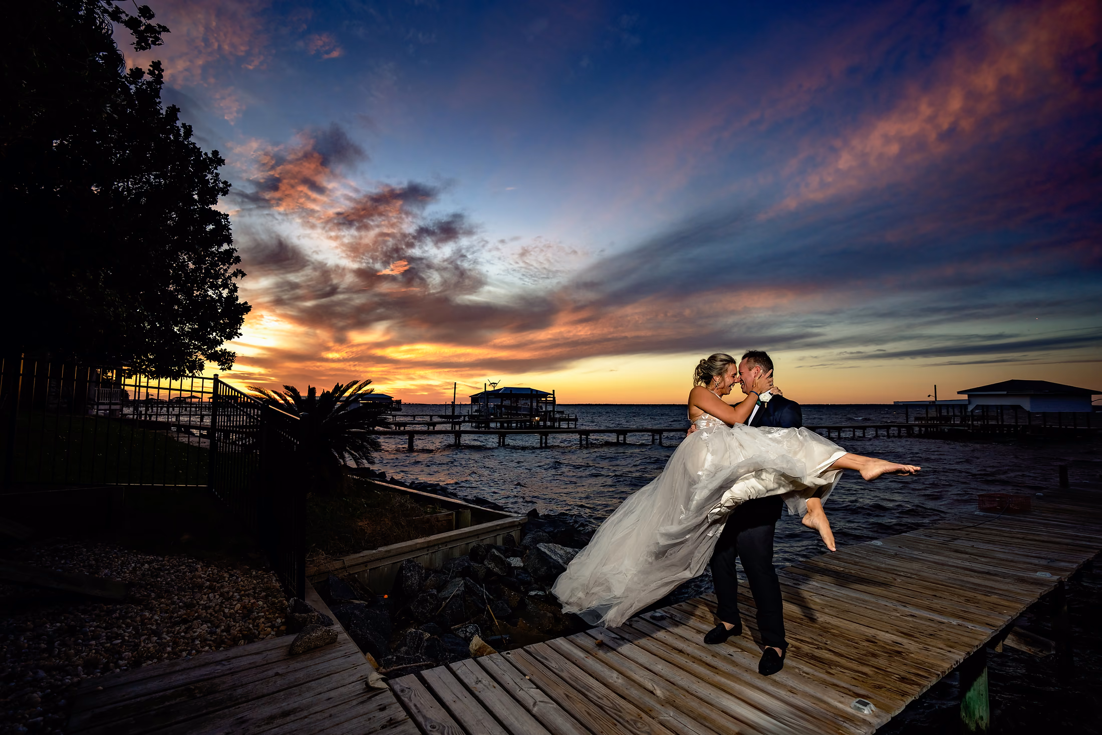 Couple silhouetted on the dock at sunset