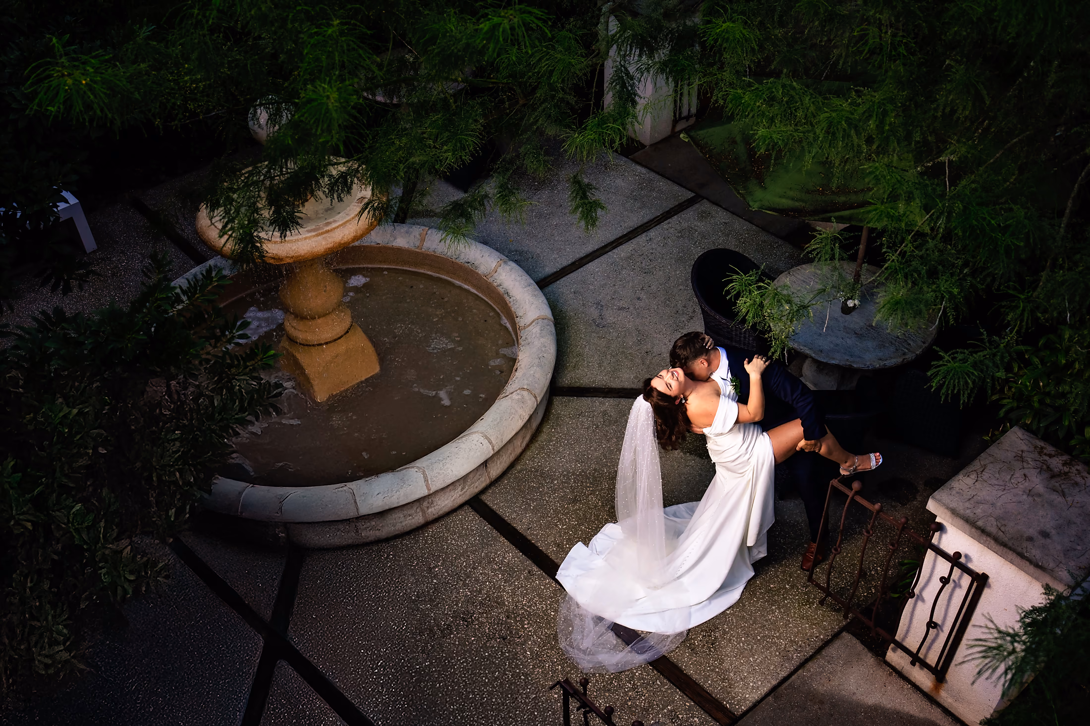 Overhead view of the couple resting by a courtyard fountain