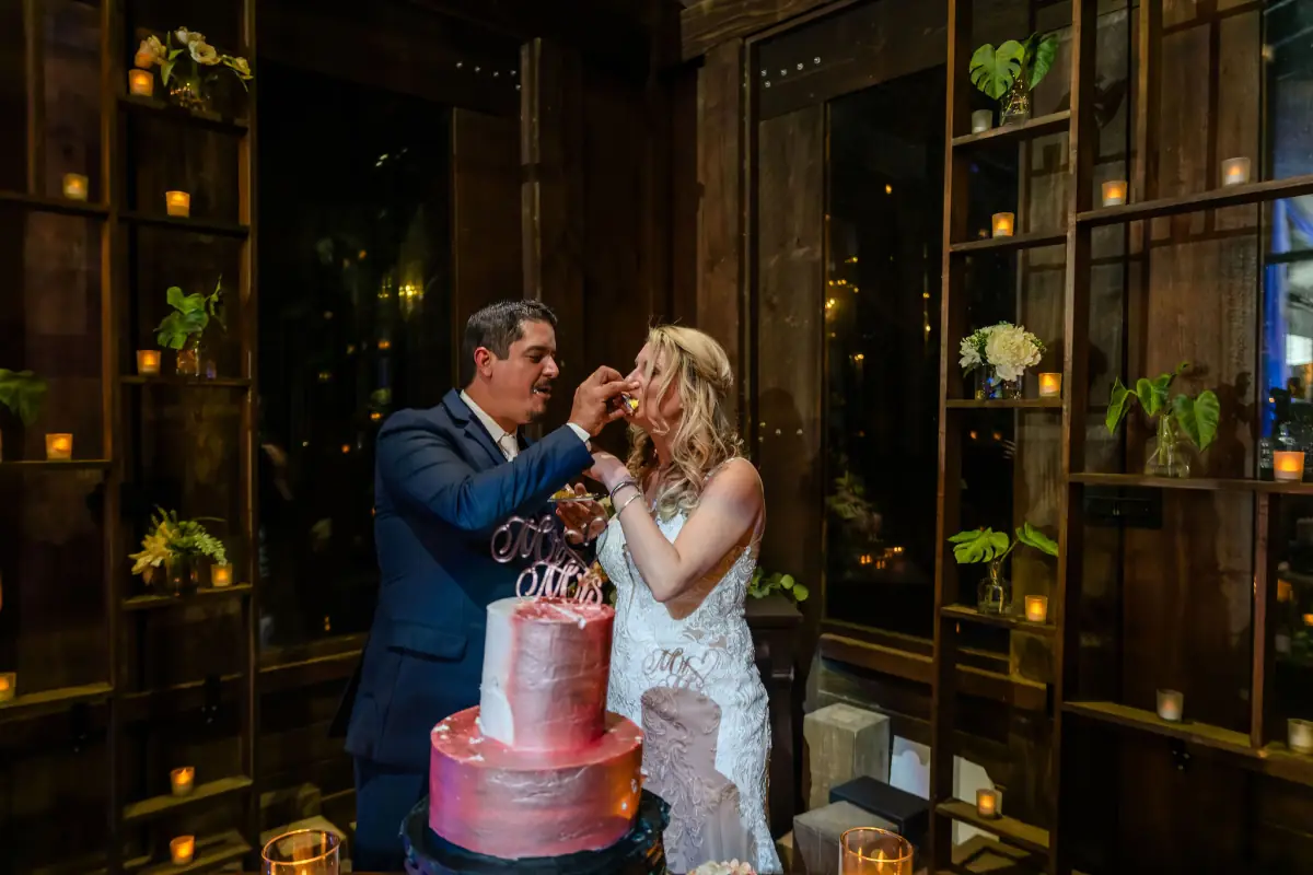 Bride and groom beside the cake in the candlelit barn at Live Oak Plantation