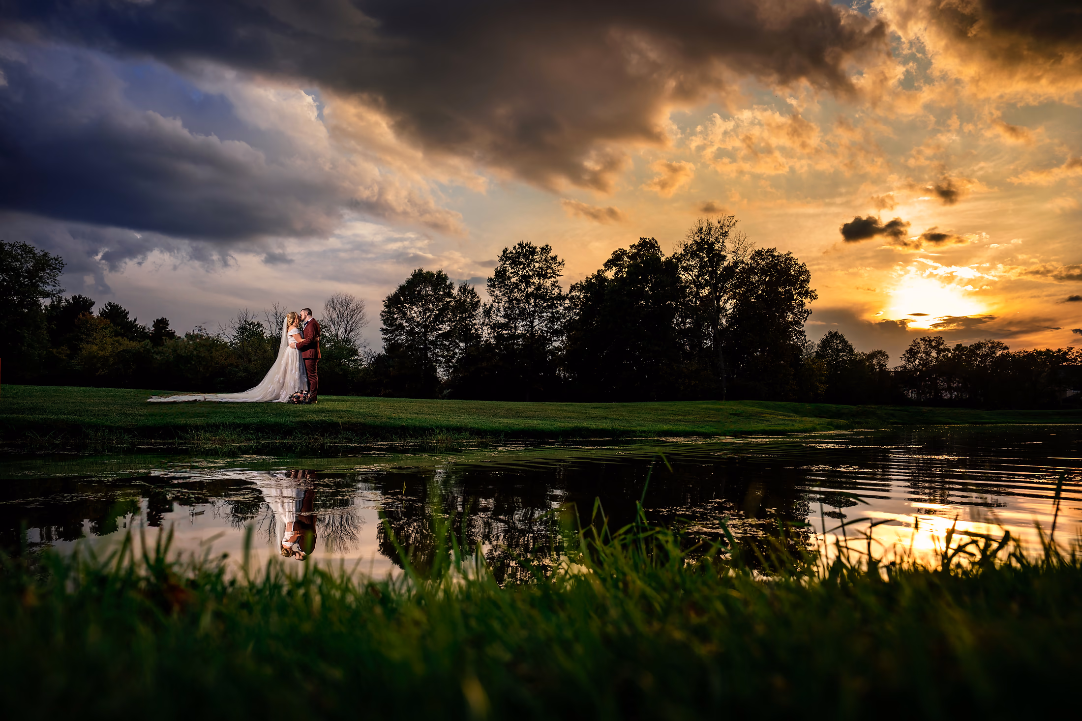 Bride beside the water under a deep evening sky