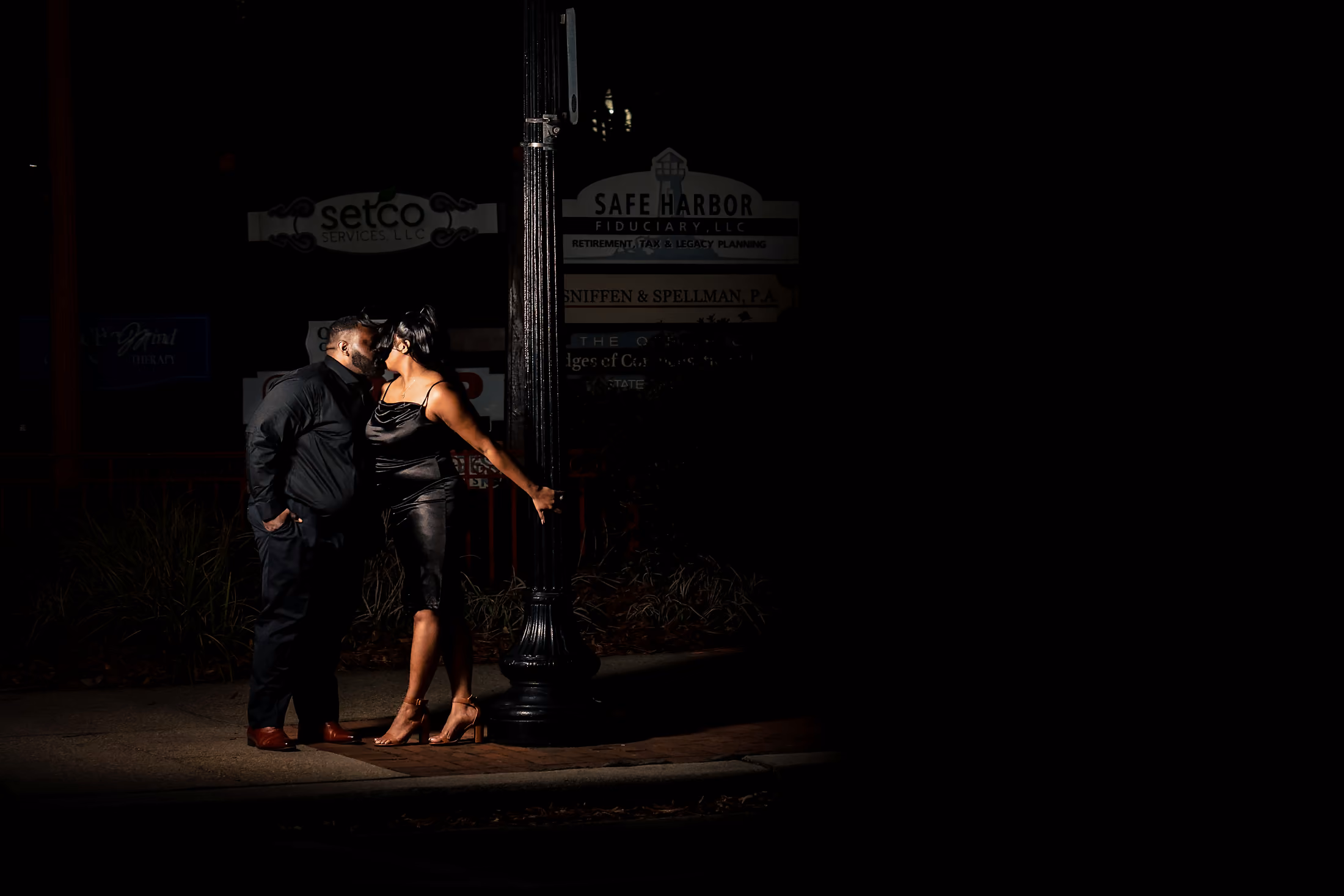 Couple dancing in a pool of light after dark