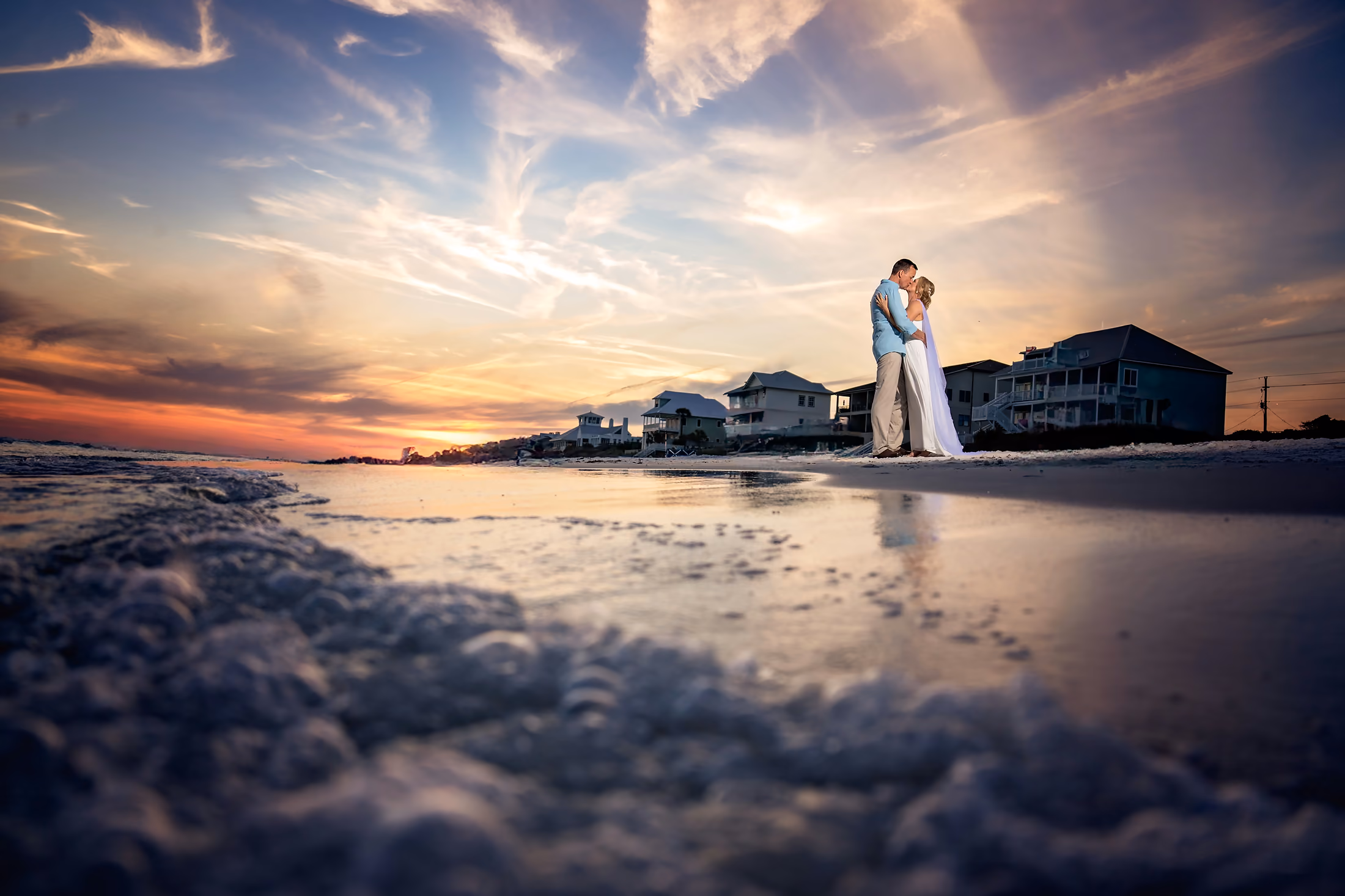 Couple on the beach beneath a vivid sunset
