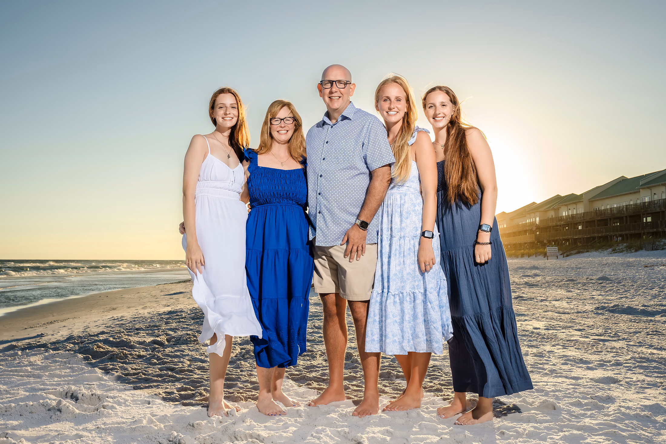 Family in blue together on the beach at sunset