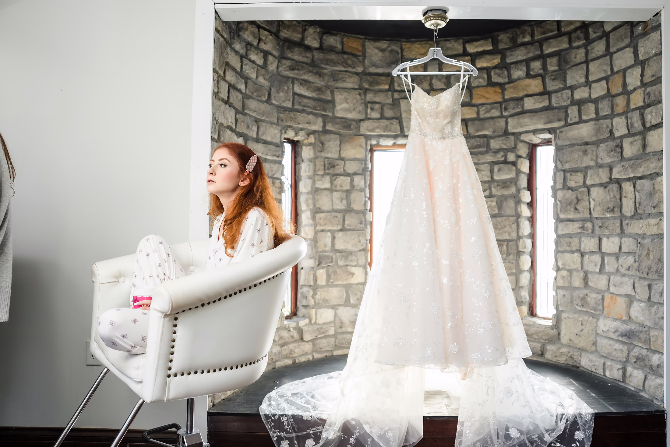 Wedding gown hanging in the window light
