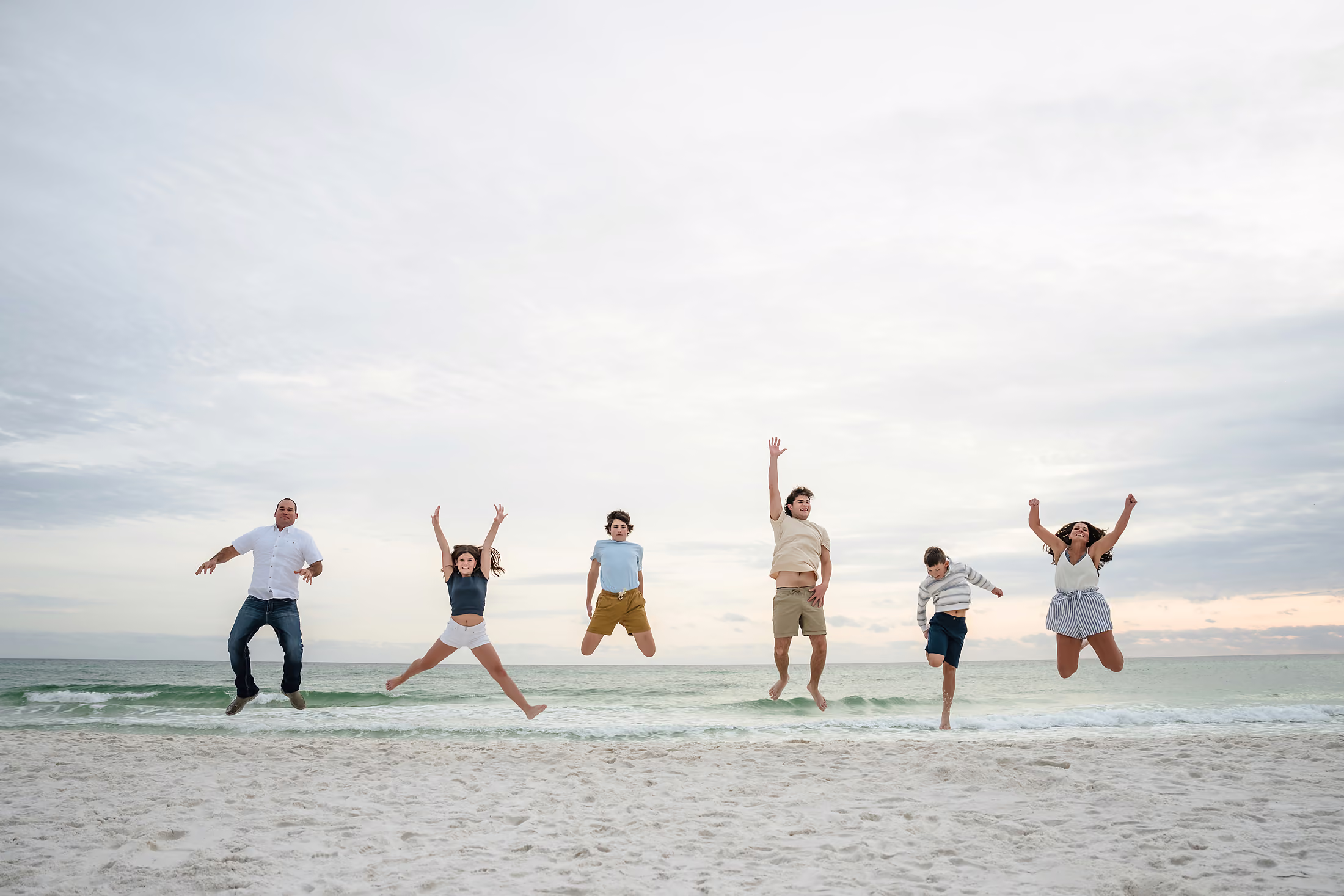 Group leaping together along the beach