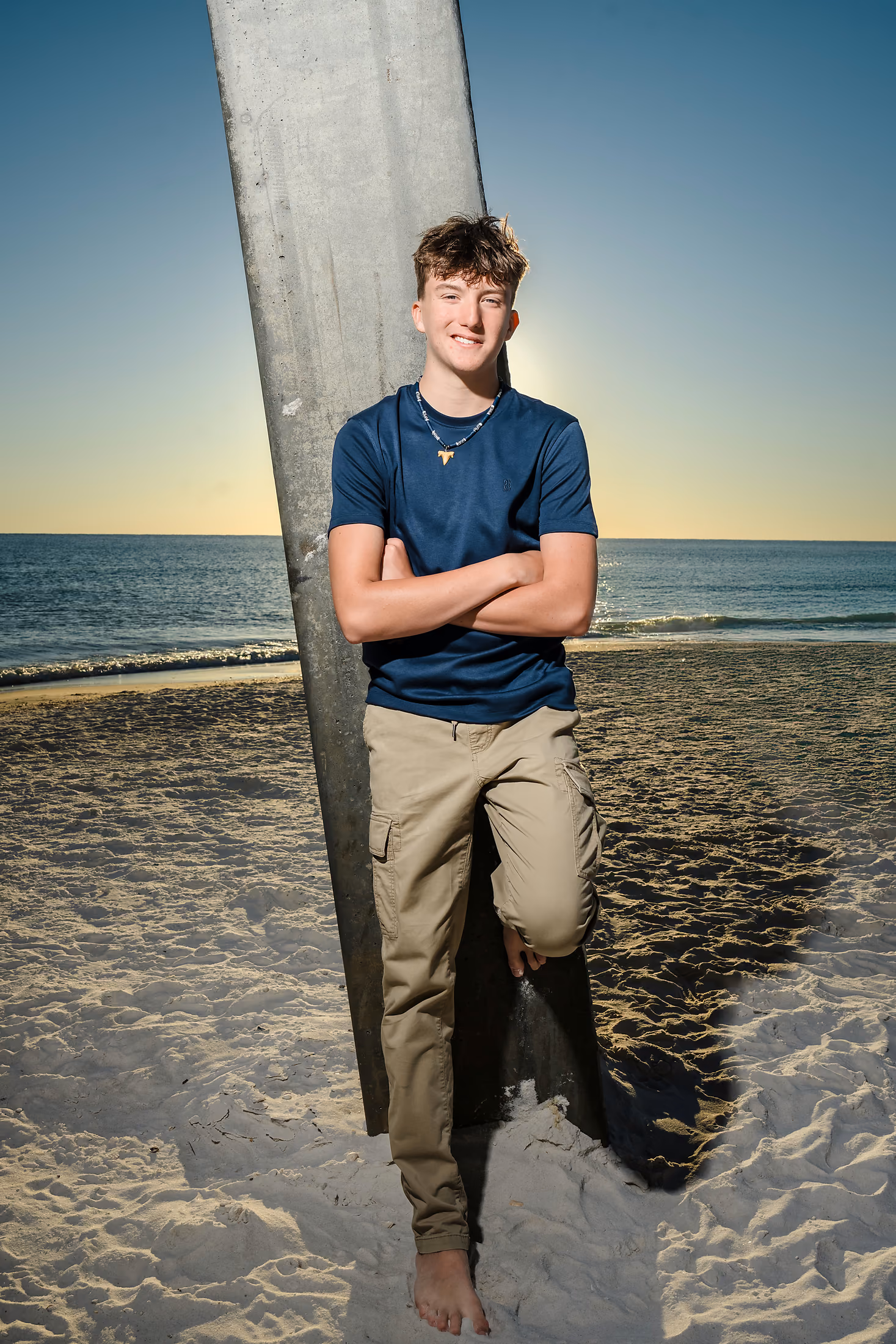 Teenage boy leaning against a pier piling