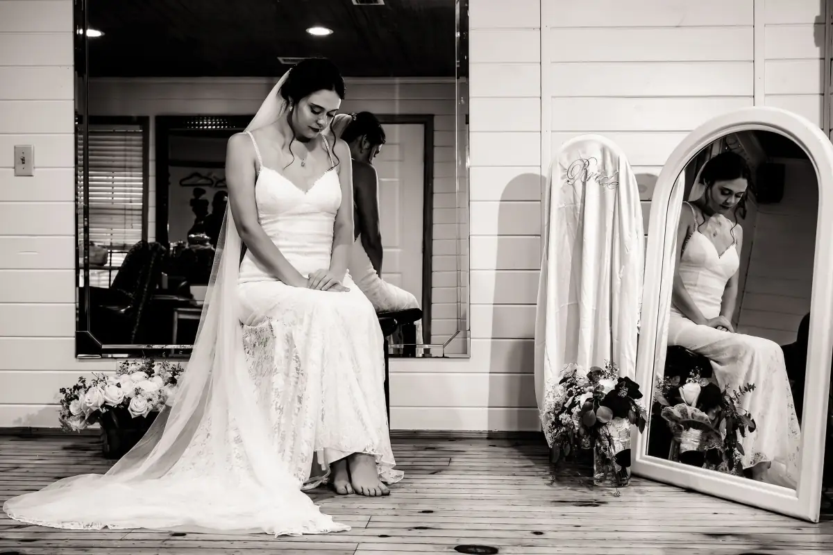 Bride getting ready, reflected in the mirror of the prep room