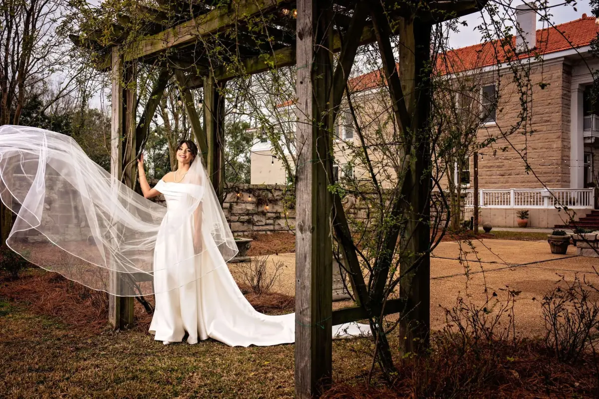 Bride with her veil among bare trees