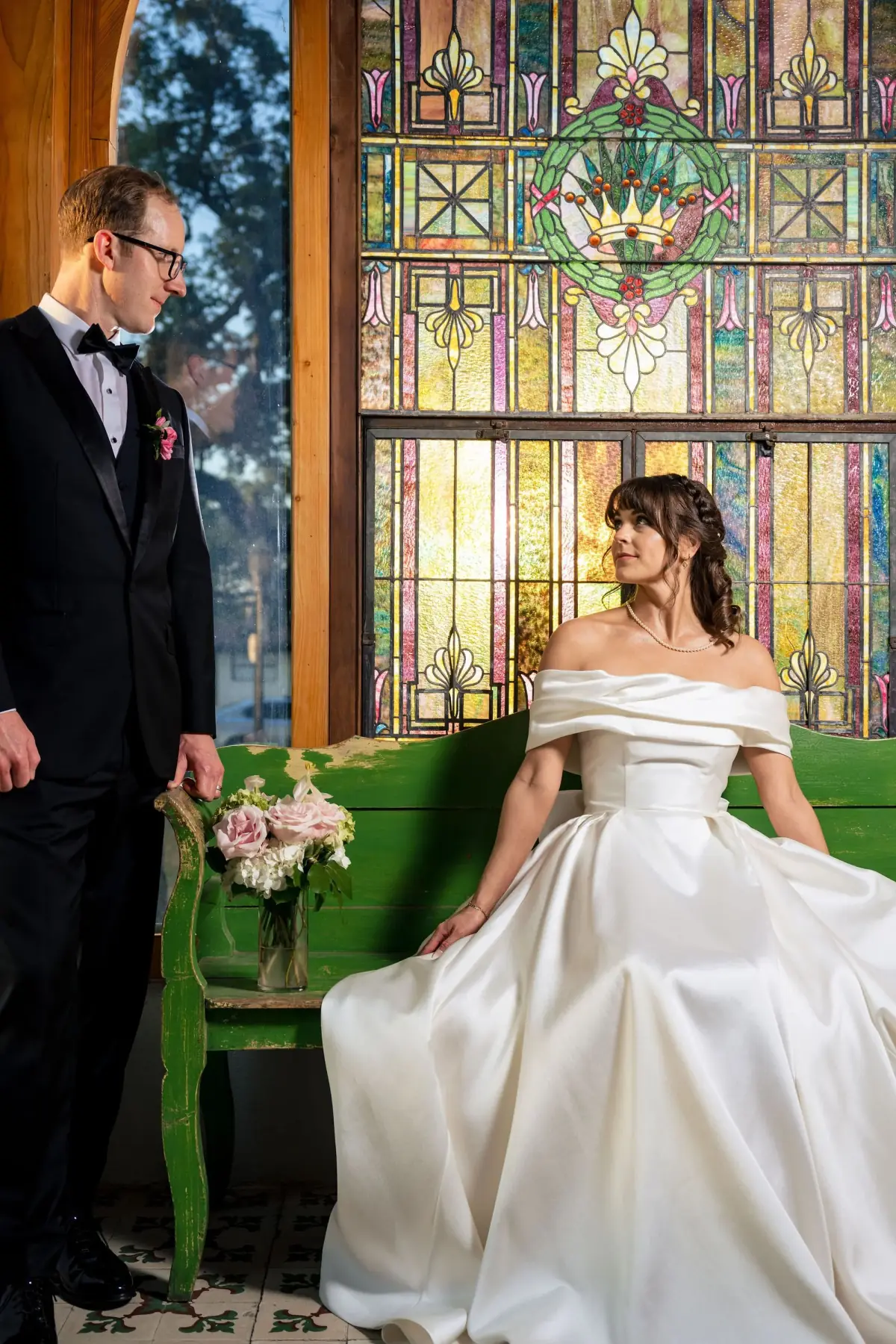 Couple on the green velvet sofa by stained glass