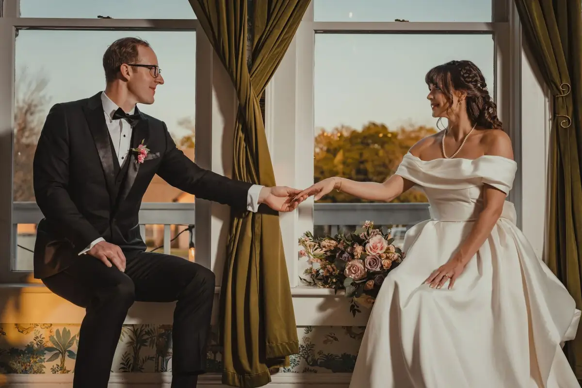 Groom reaching for his bride hand