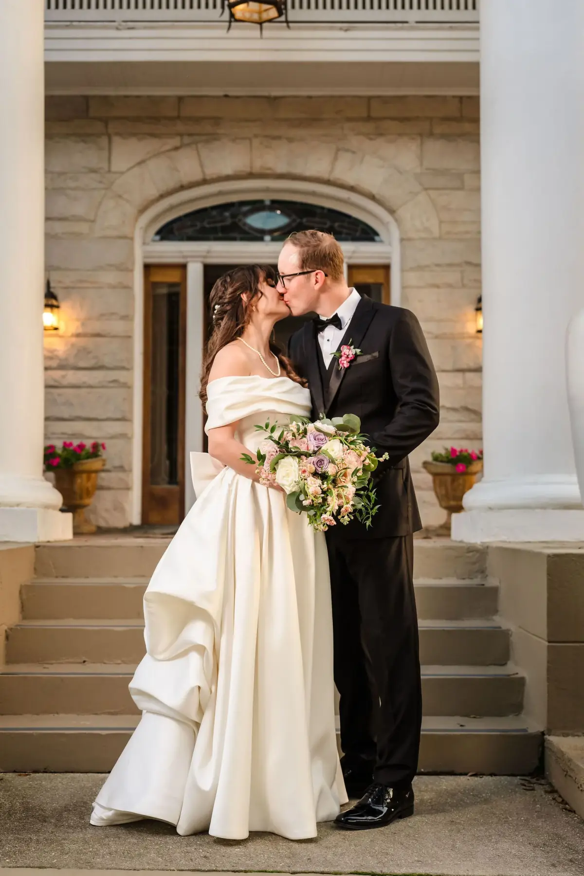 Bride with her bouquet on the columned porch