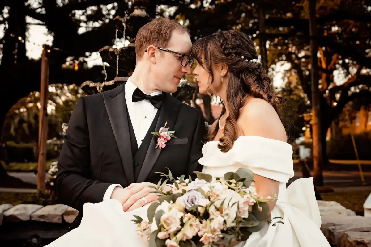 Couple kissing under string lights at night
