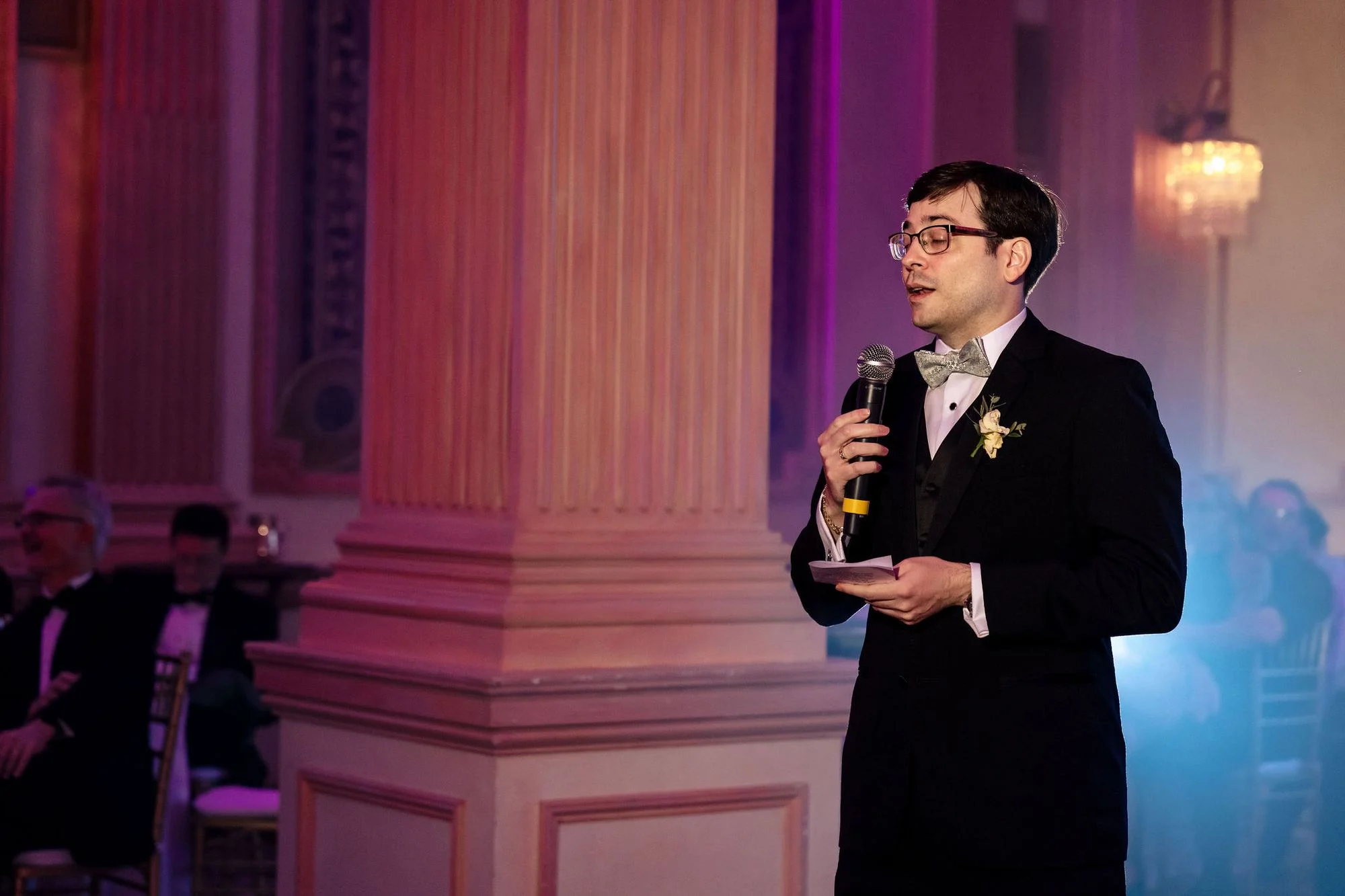 Groom with a drink in the rosy ballroom