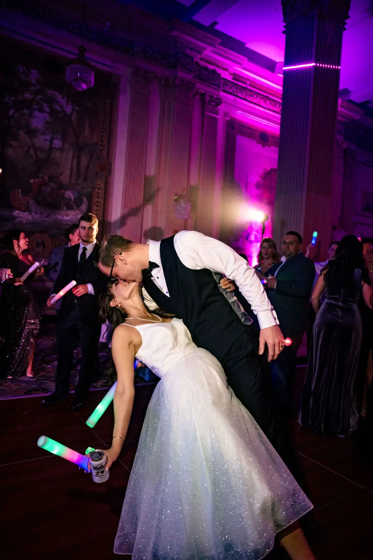 Groom dipping his bride as guests watch