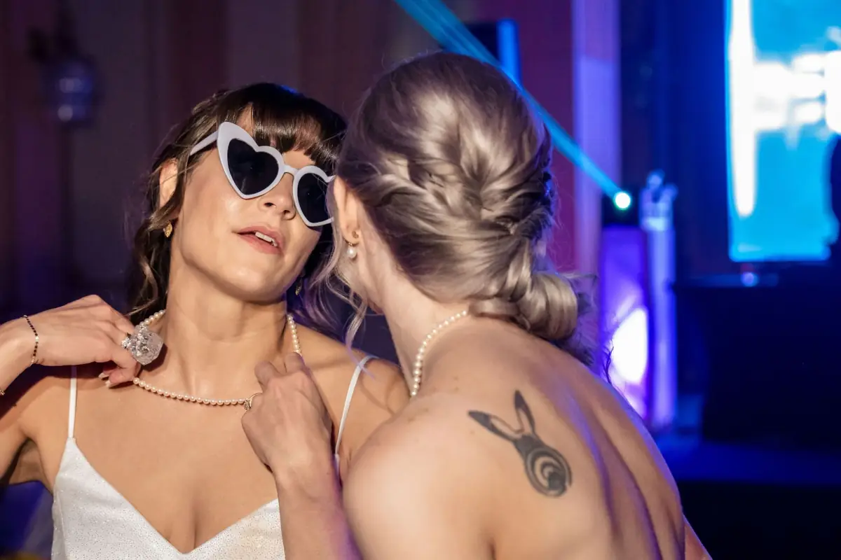 Playful embrace, bride in sunglasses