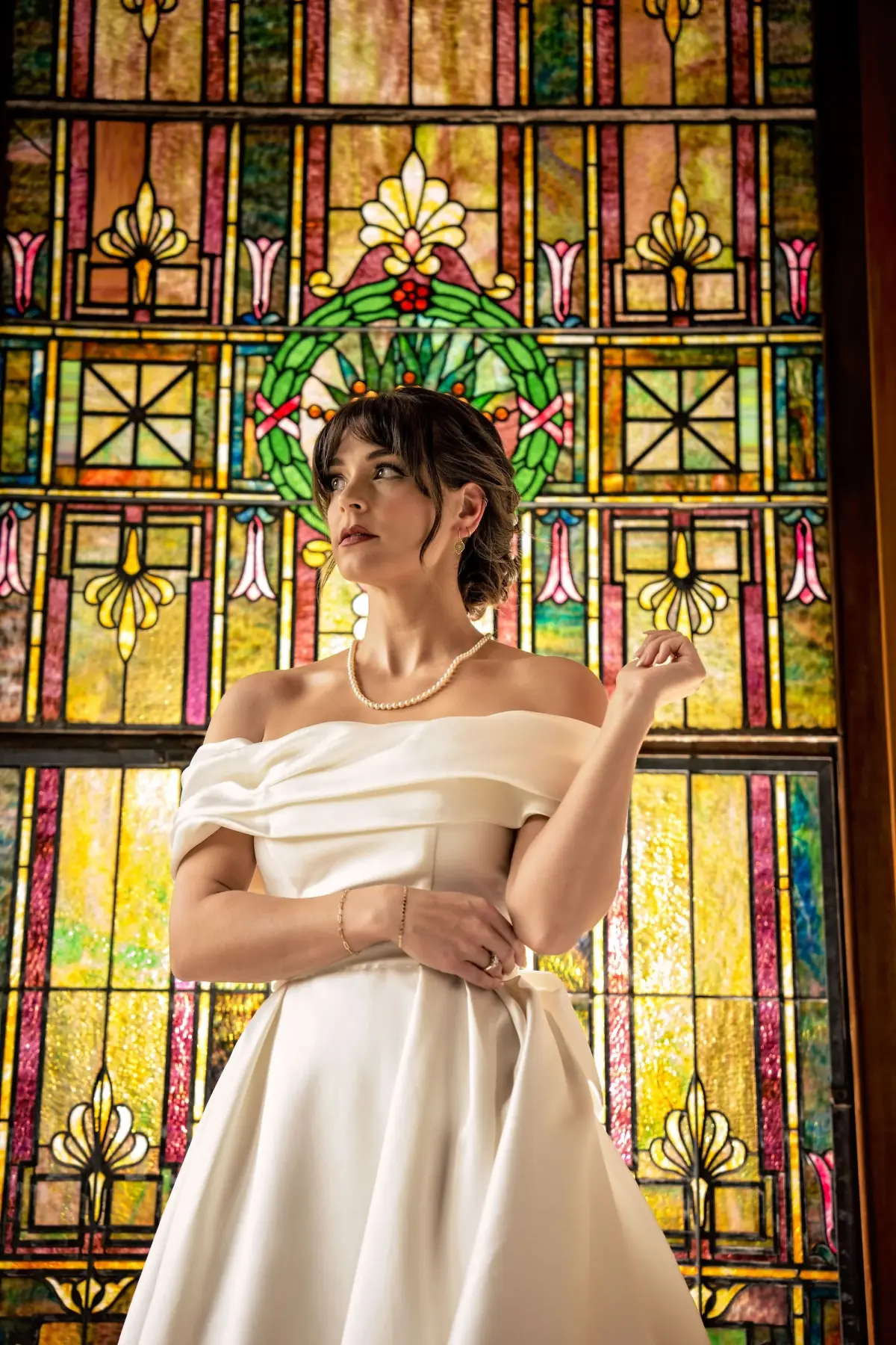 Bride beside a luminous stained-glass window