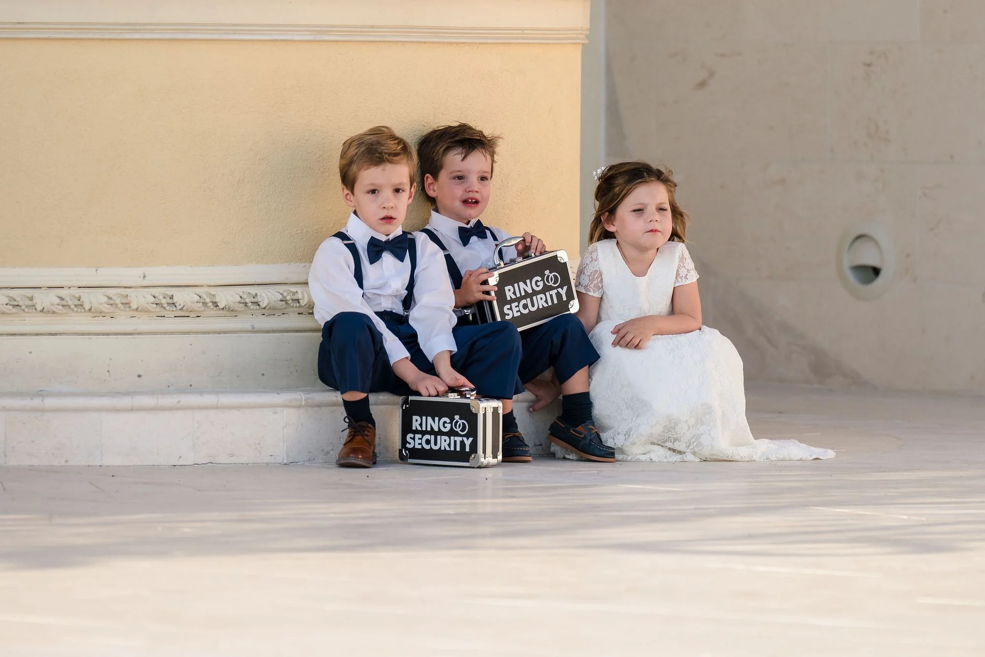 Ring bearer resting on the steps with his sign