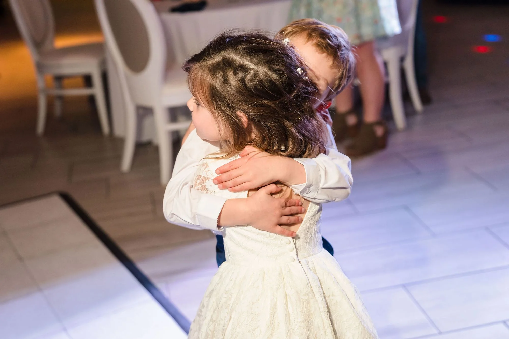 Two little ones waiting on white chairs