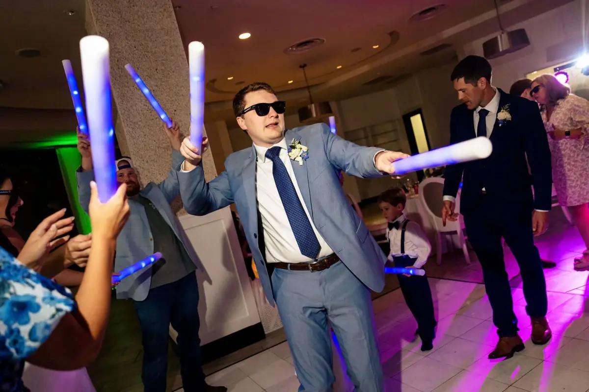 Groom with a glow stick and sunglasses