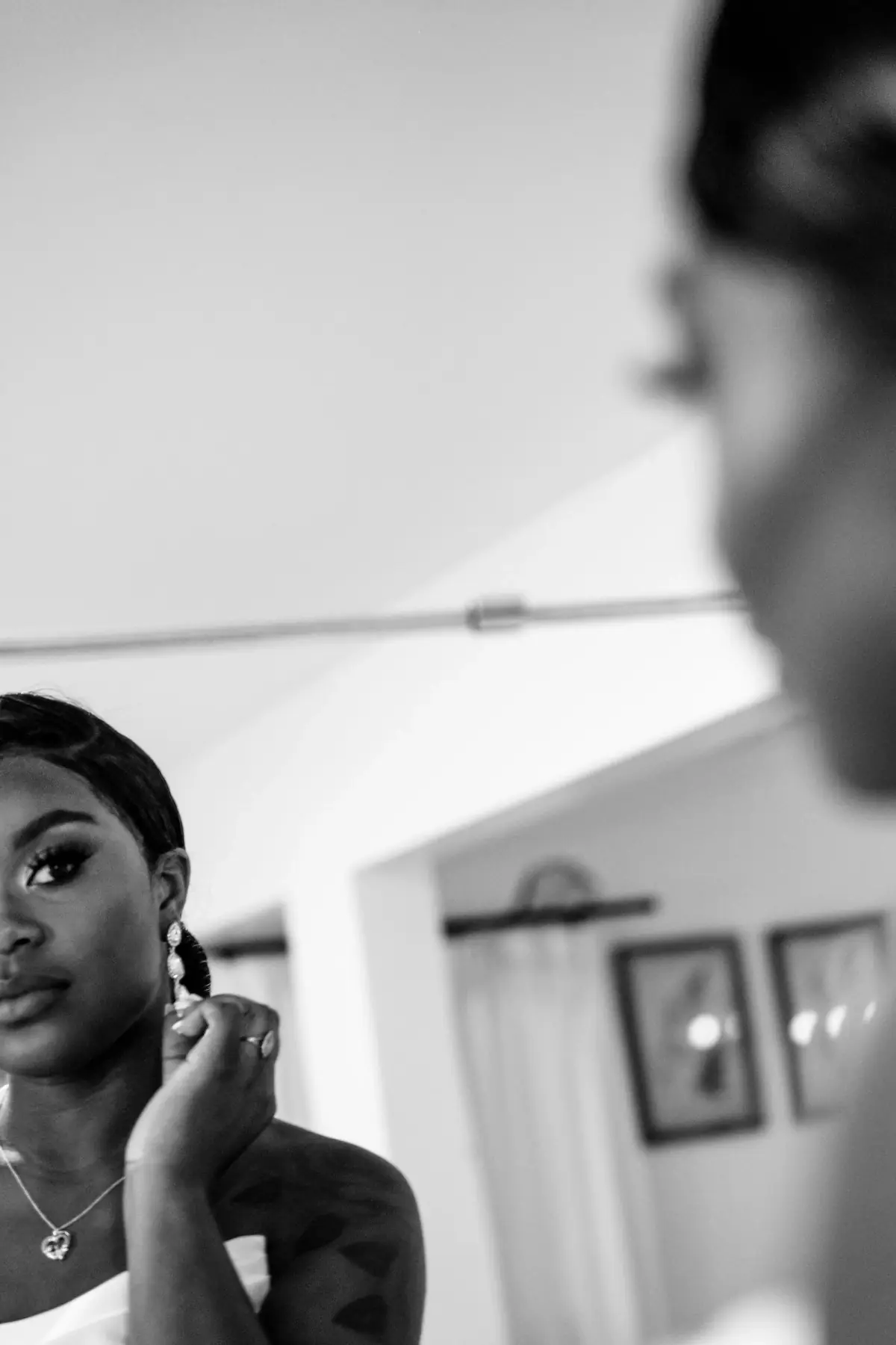 Black-and-white bride fastening her earring