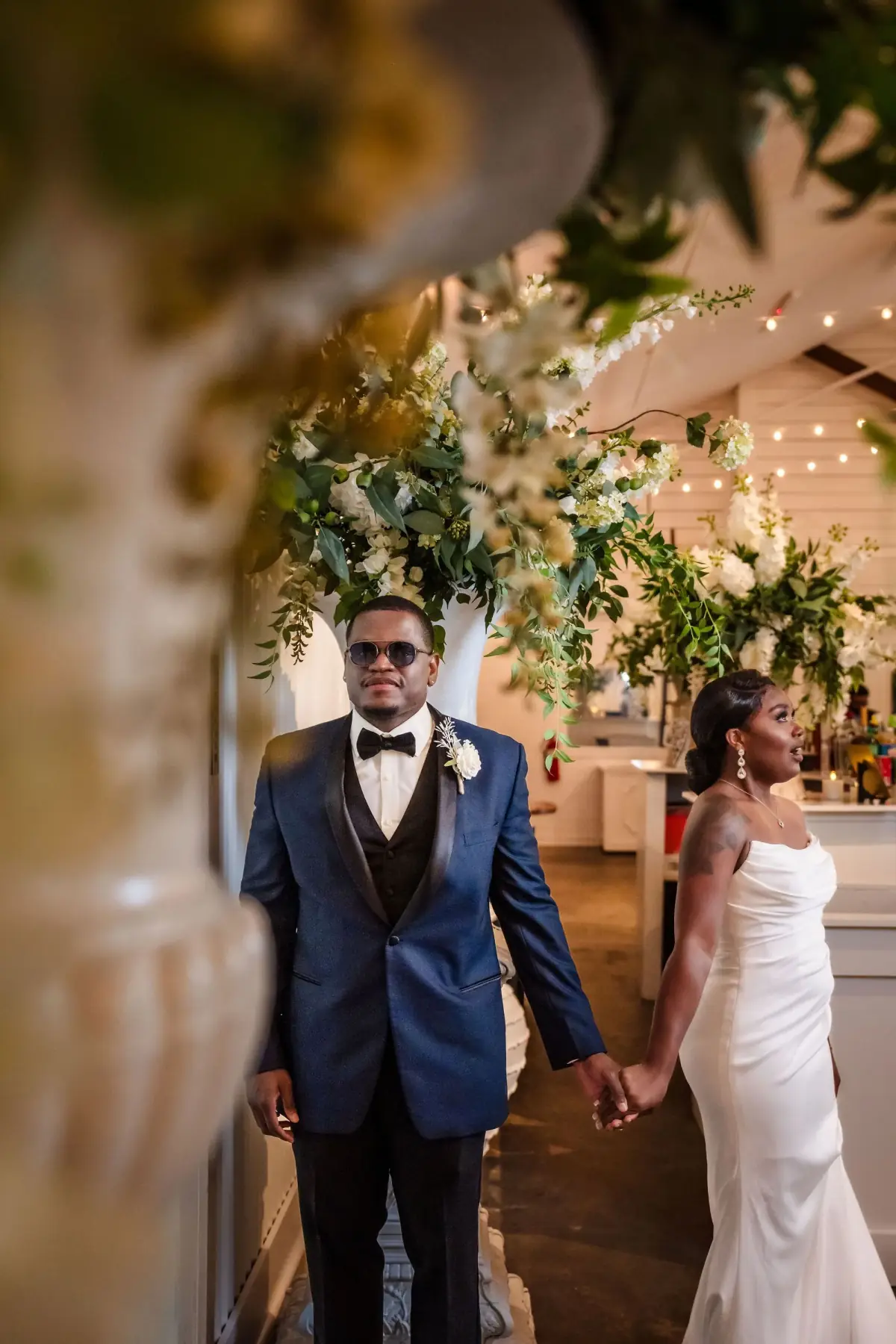 Groom waiting by the florals at the barn