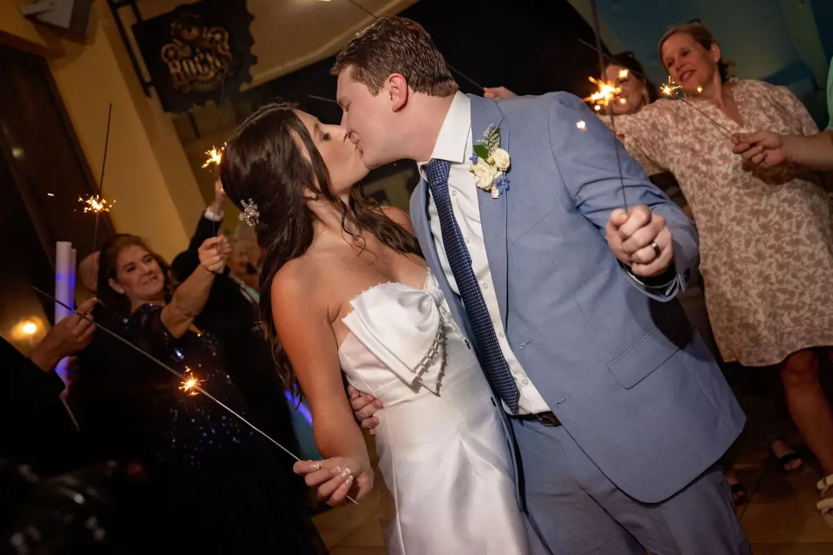 Couple dancing close beneath string lights